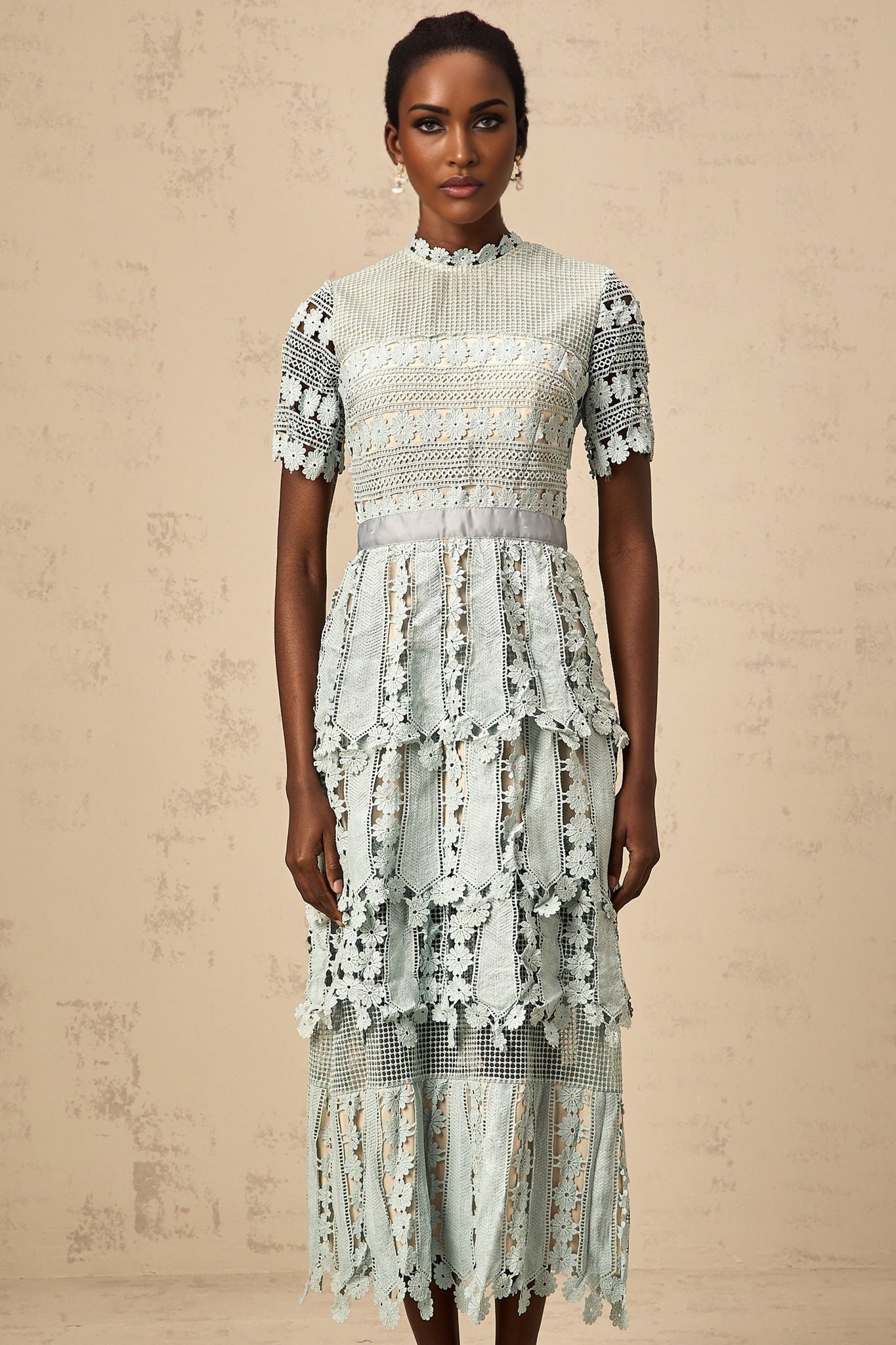 A green midi dress with floral embroidery patterns featuring a design inspired by the ocean