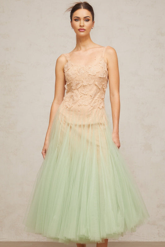 A green midi dress with lace panelling and tulle fabric featuring a feminine silhouette and delicate details