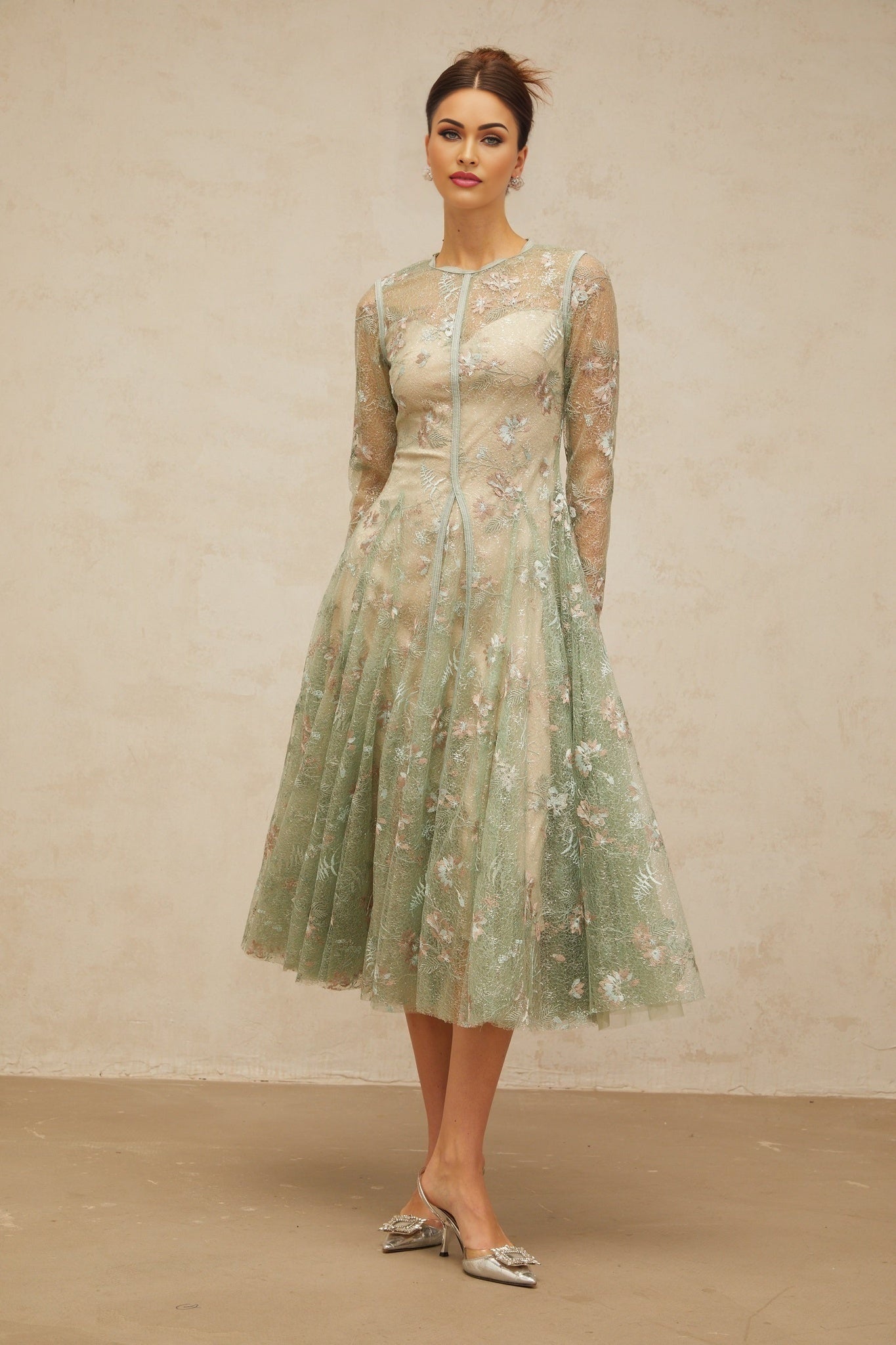 A green pleated midi dress with floral embroidery details featuring a design called Philomene