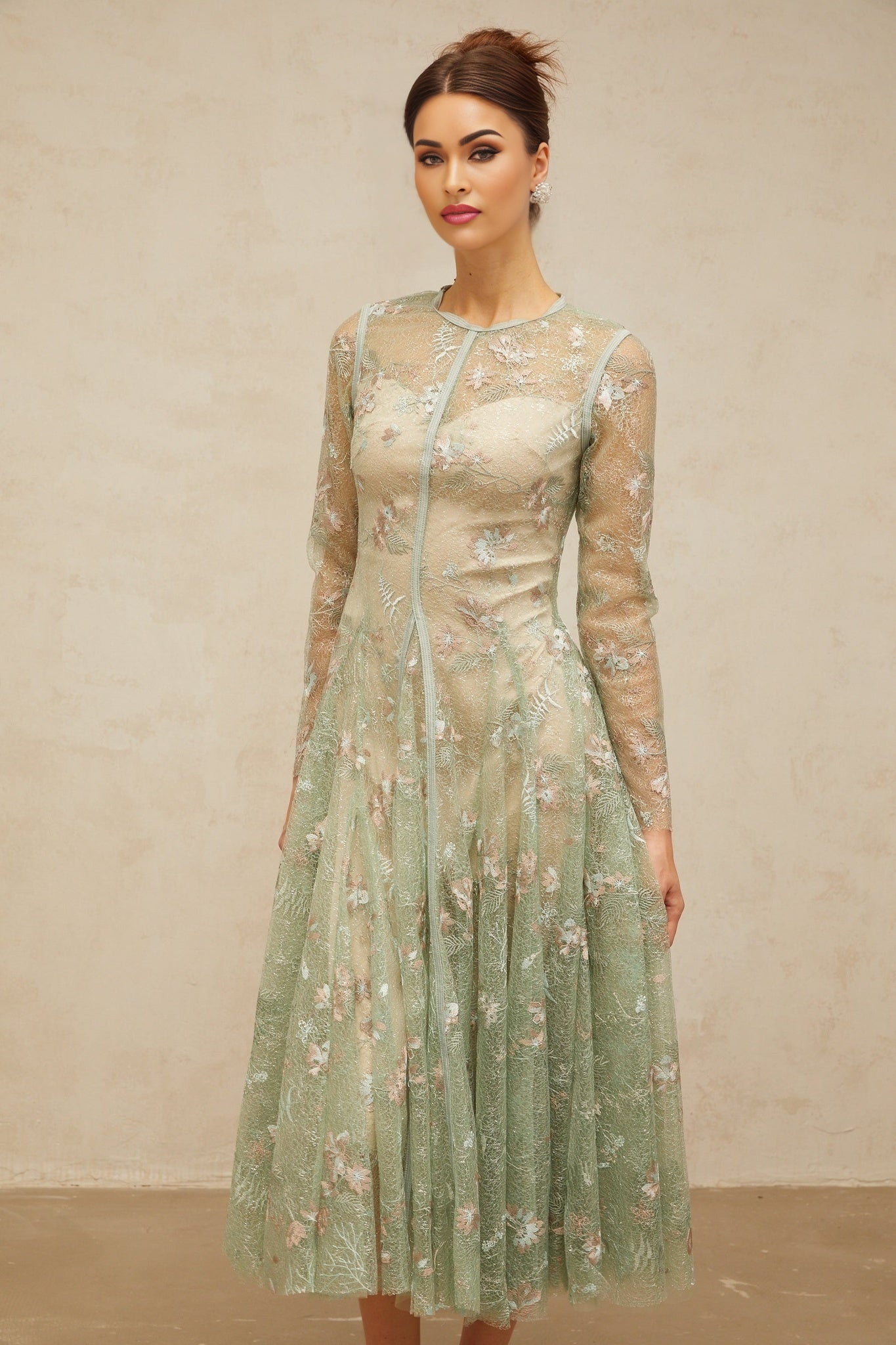 A green pleated midi dress with floral embroidery details named Philomene shown on a mannequin or model against a plain background