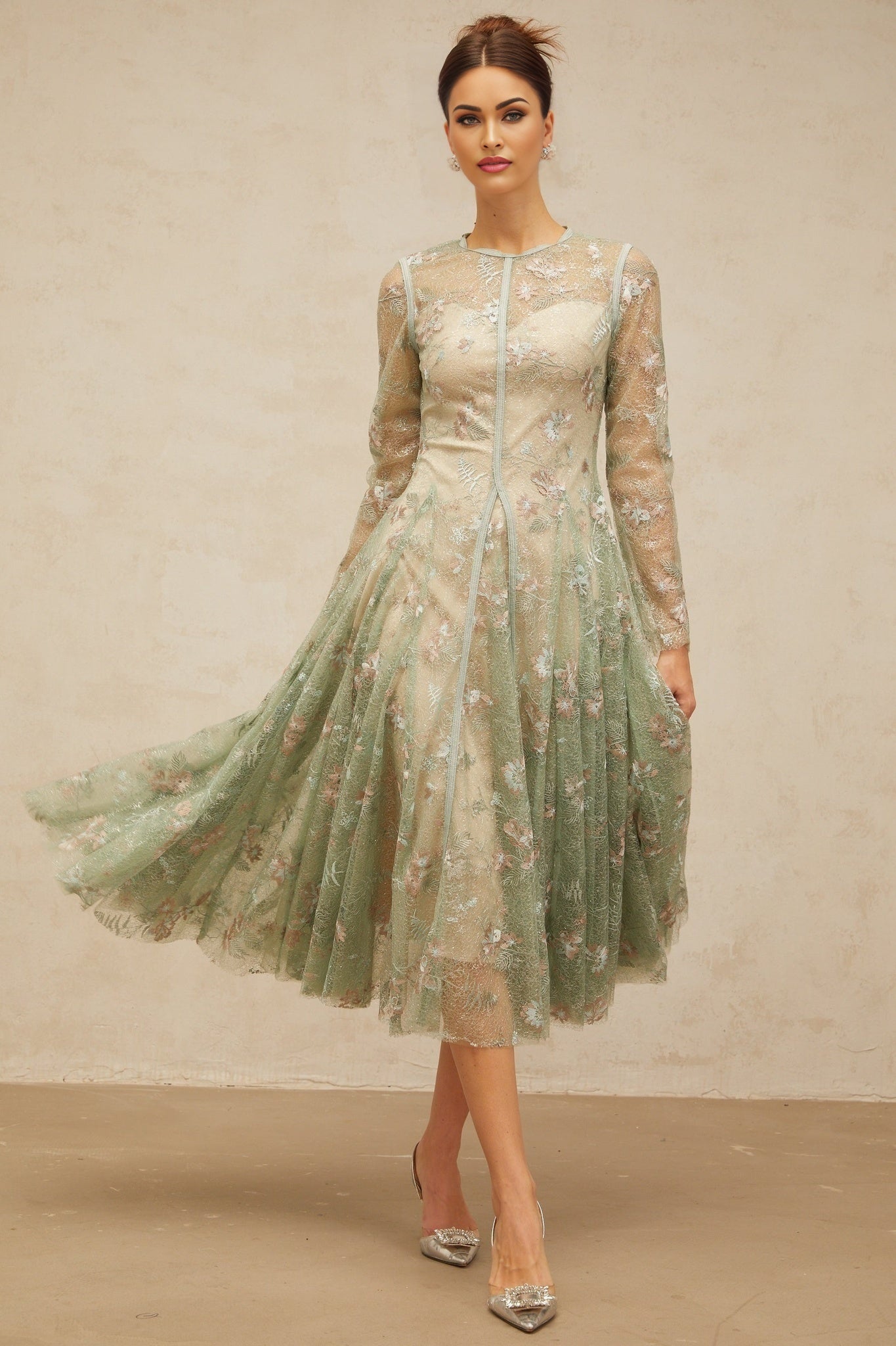 A green pleated midi dress with floral embroidery named Philomene featuring a flowing silhouette and delicate flower details throughout the fabric