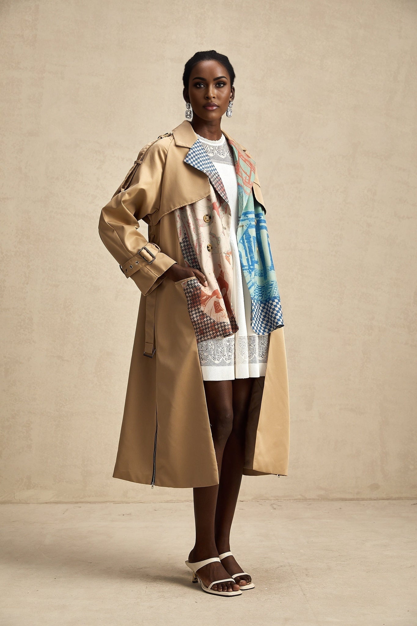 A Josephine trench coat with contrasting colors and a printed design featuring a belted waist