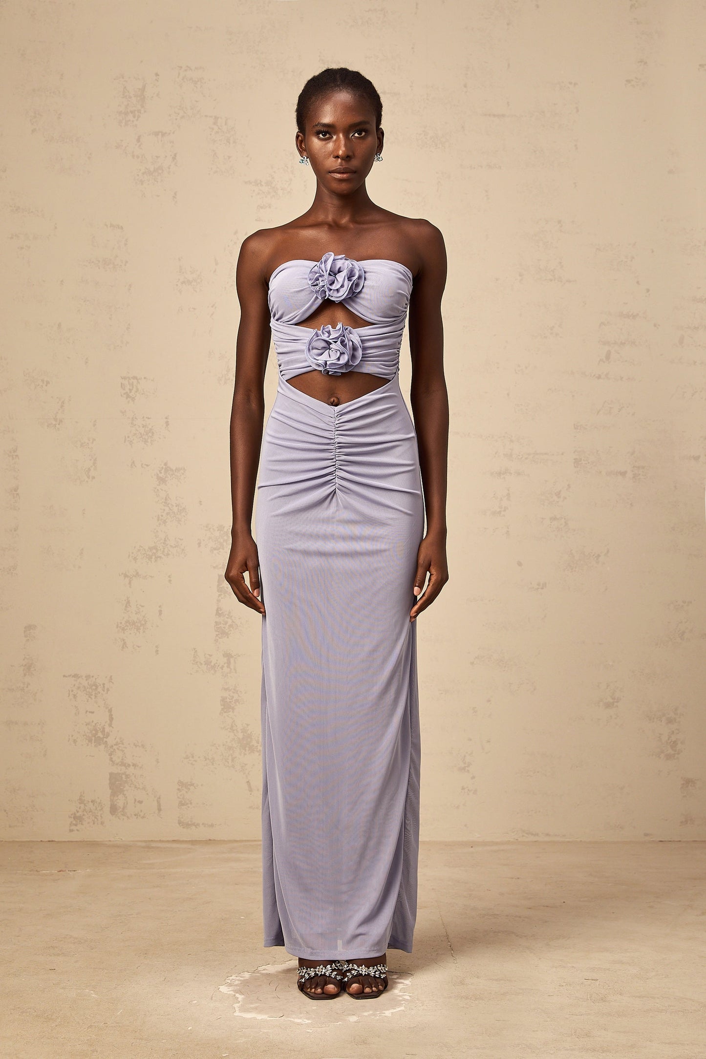 A lavender maxi dress with a corset bodice featuring 3D ruched petal details and a flowing skirt