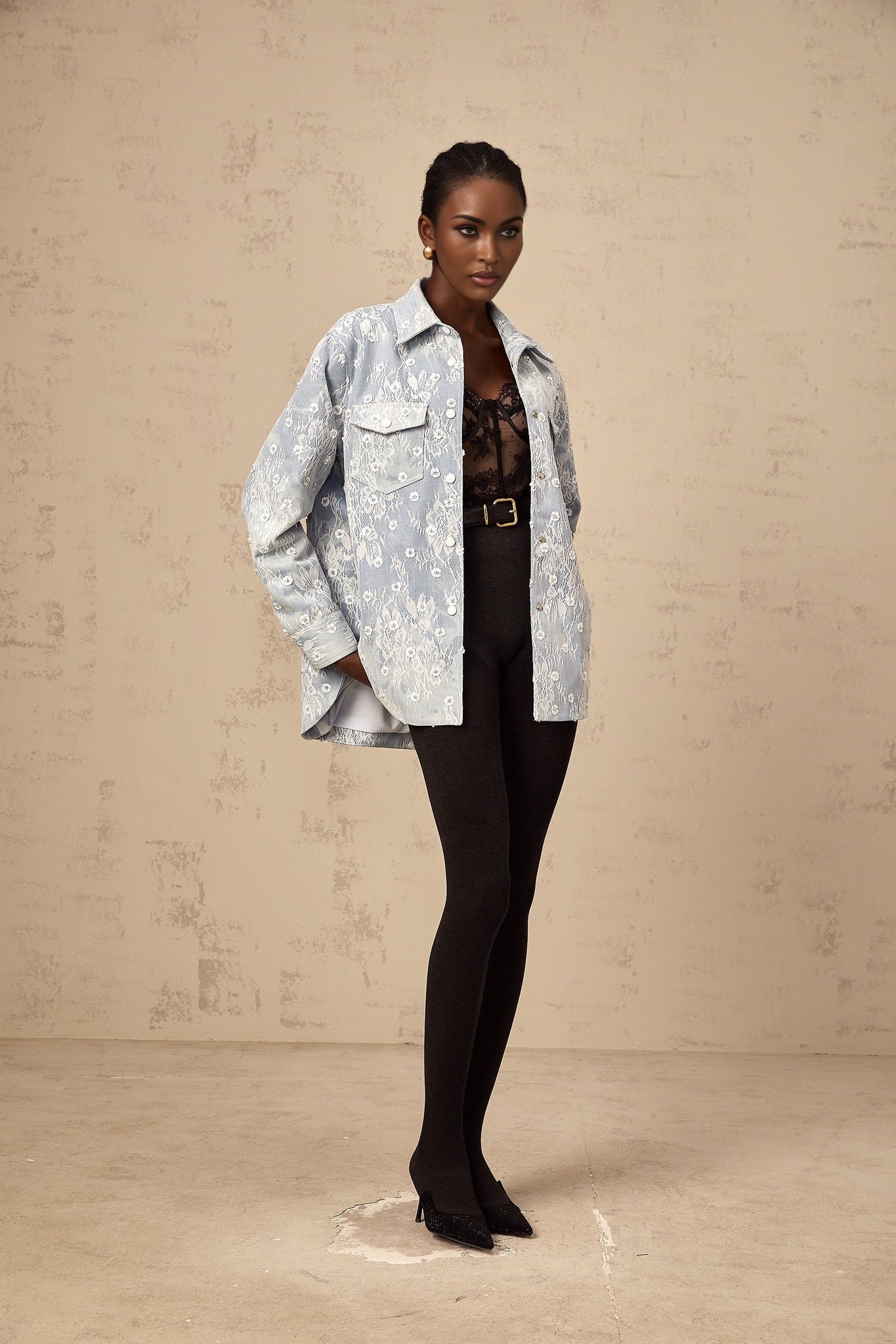 A light blue denim jacket with sequined floral appliques scattered across the fabric