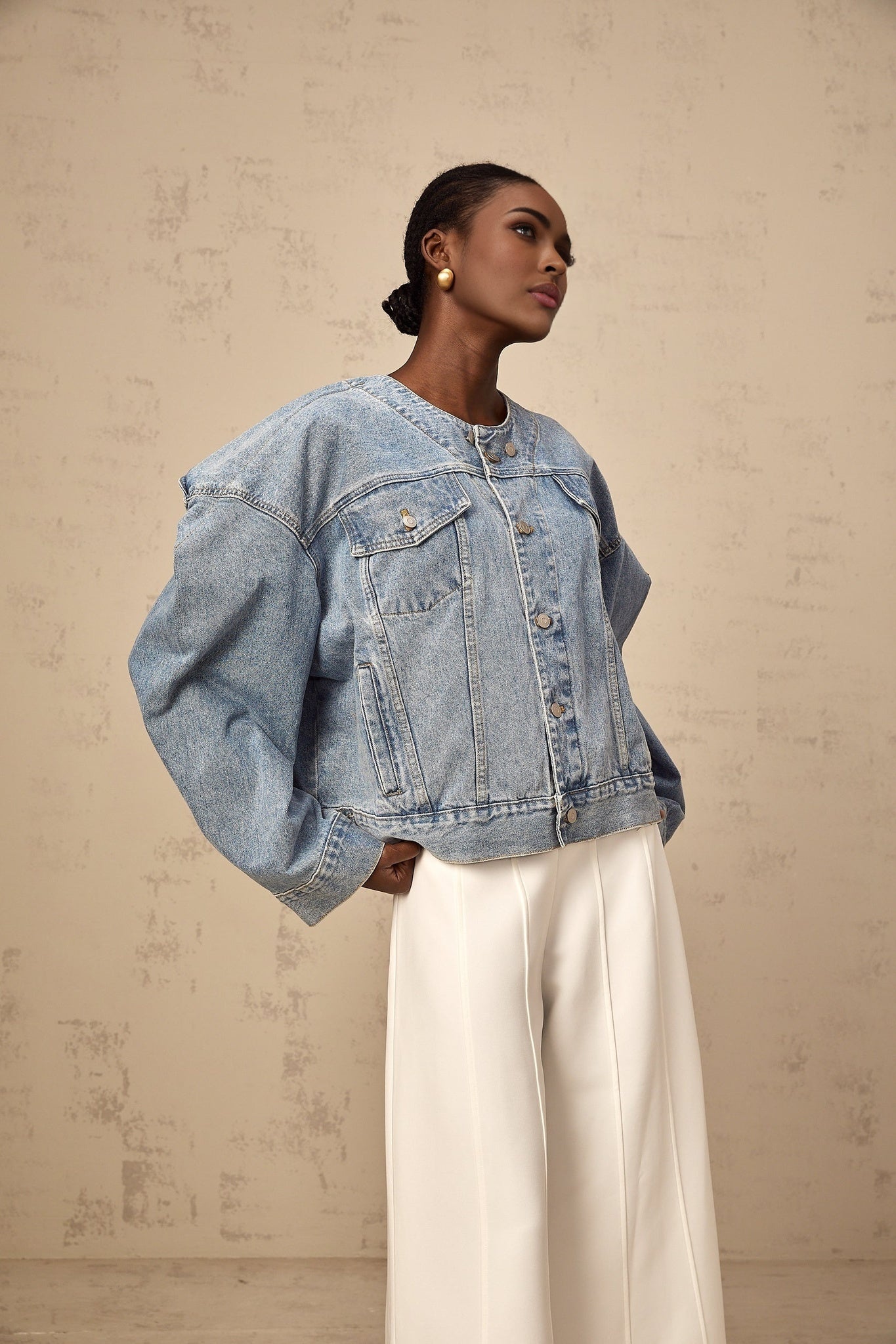 A light blue denim jacket without a collar worn by a female model