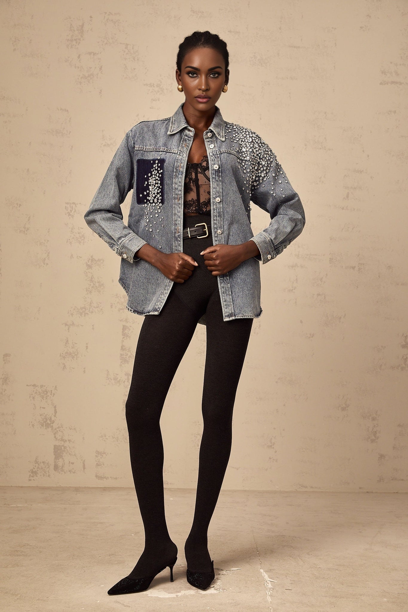 A light blue denim shirt adorned with small rhinestones scattered across the fabric creating a sparkling effect