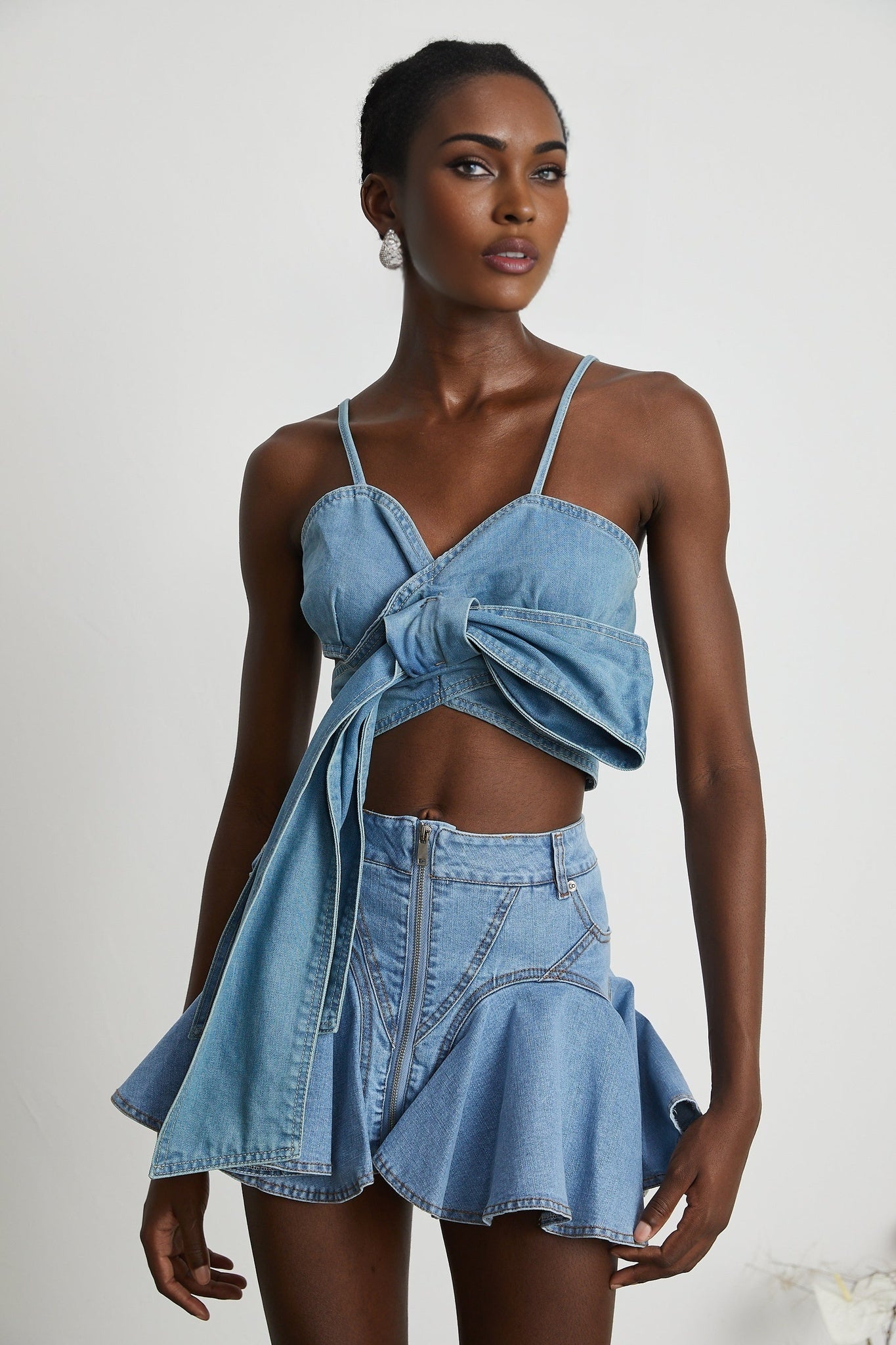 A light blue denim skirt with a ruffled hem called Capucine featuring a volant style bottom edge