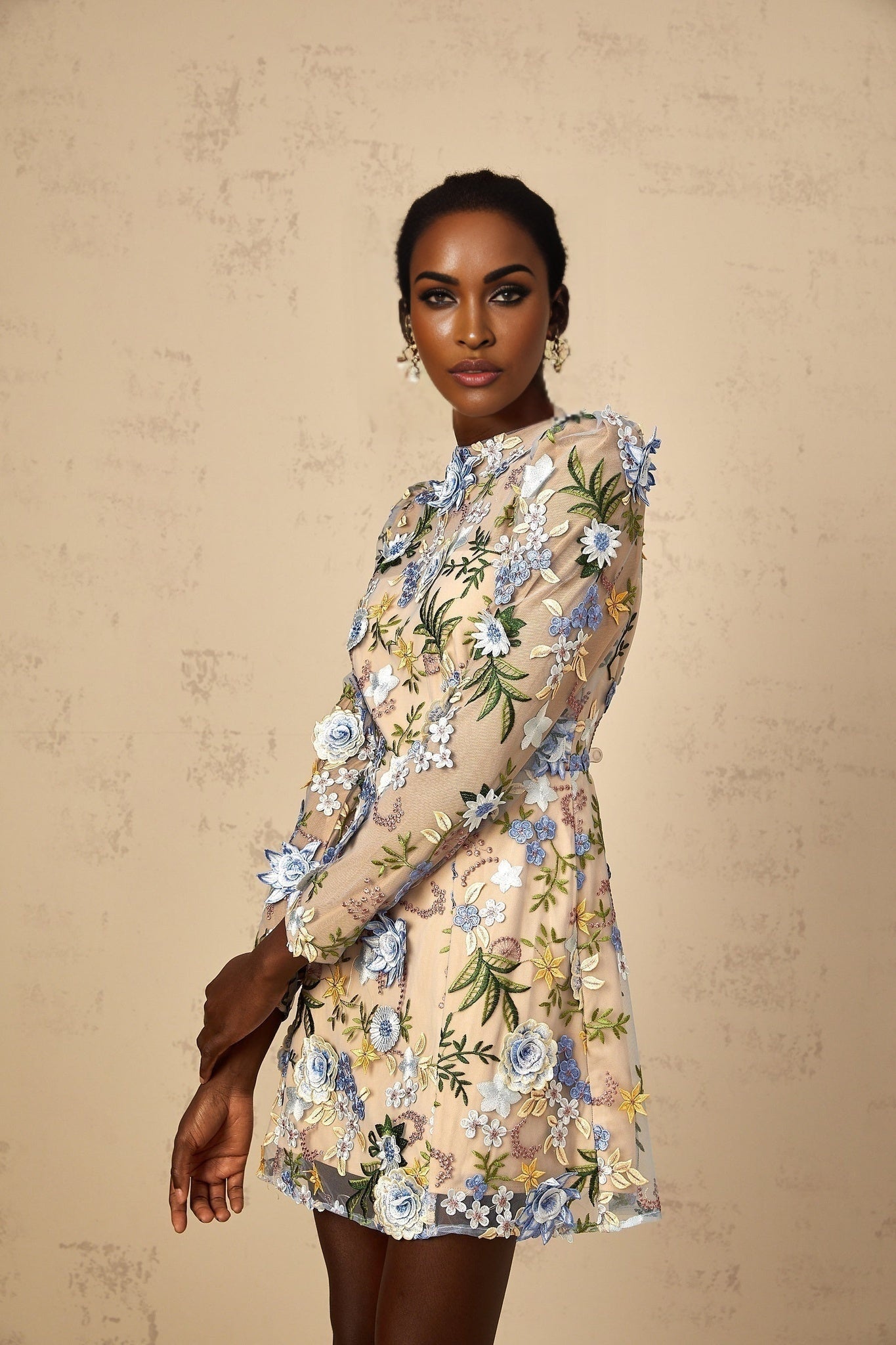 A light blue mini dress with a tulle overlay featuring delicate floral applique embroidery details throughout the garment