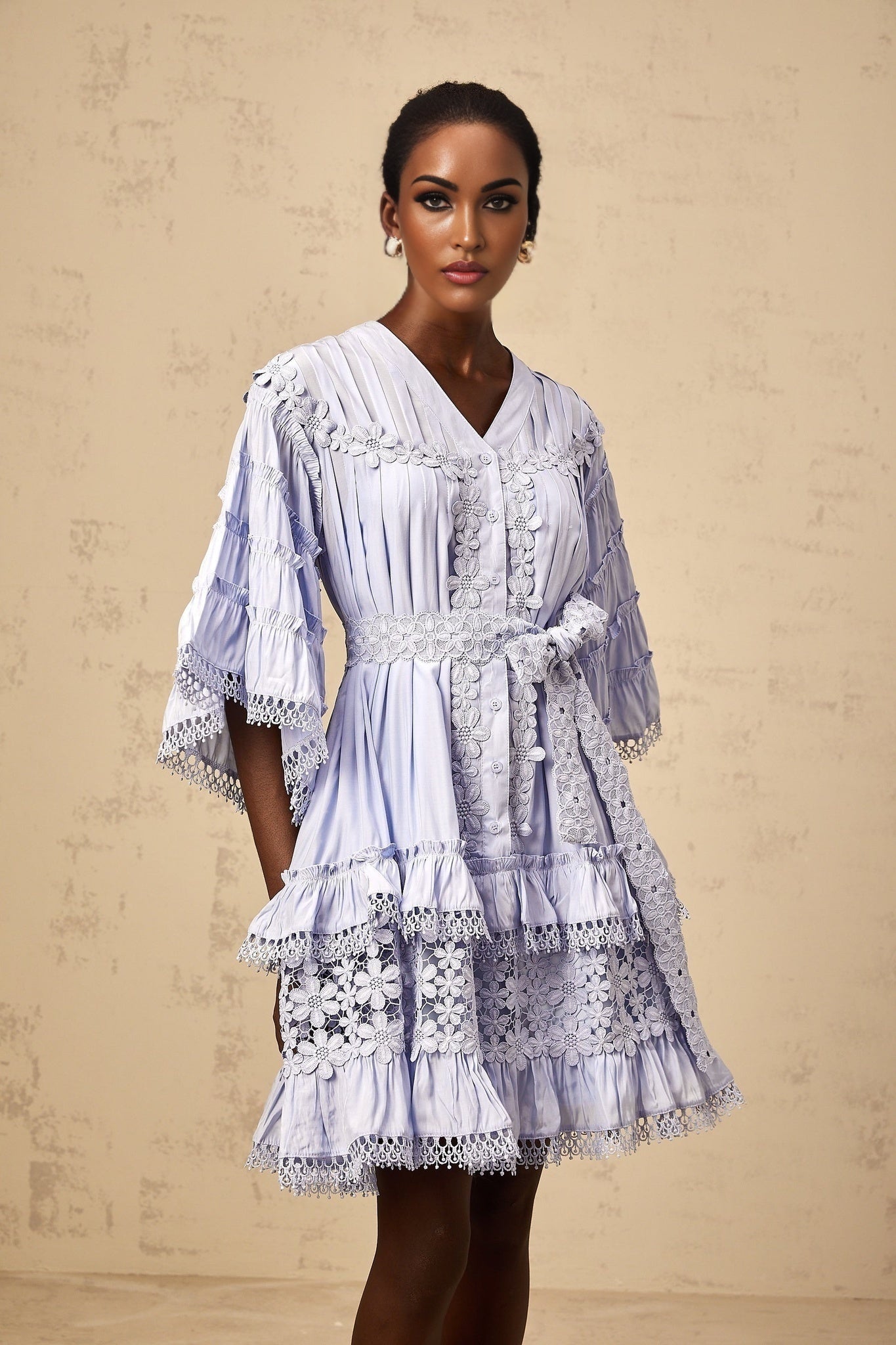 A light blue mini dress with tiered layers and delicate floral embroidery details