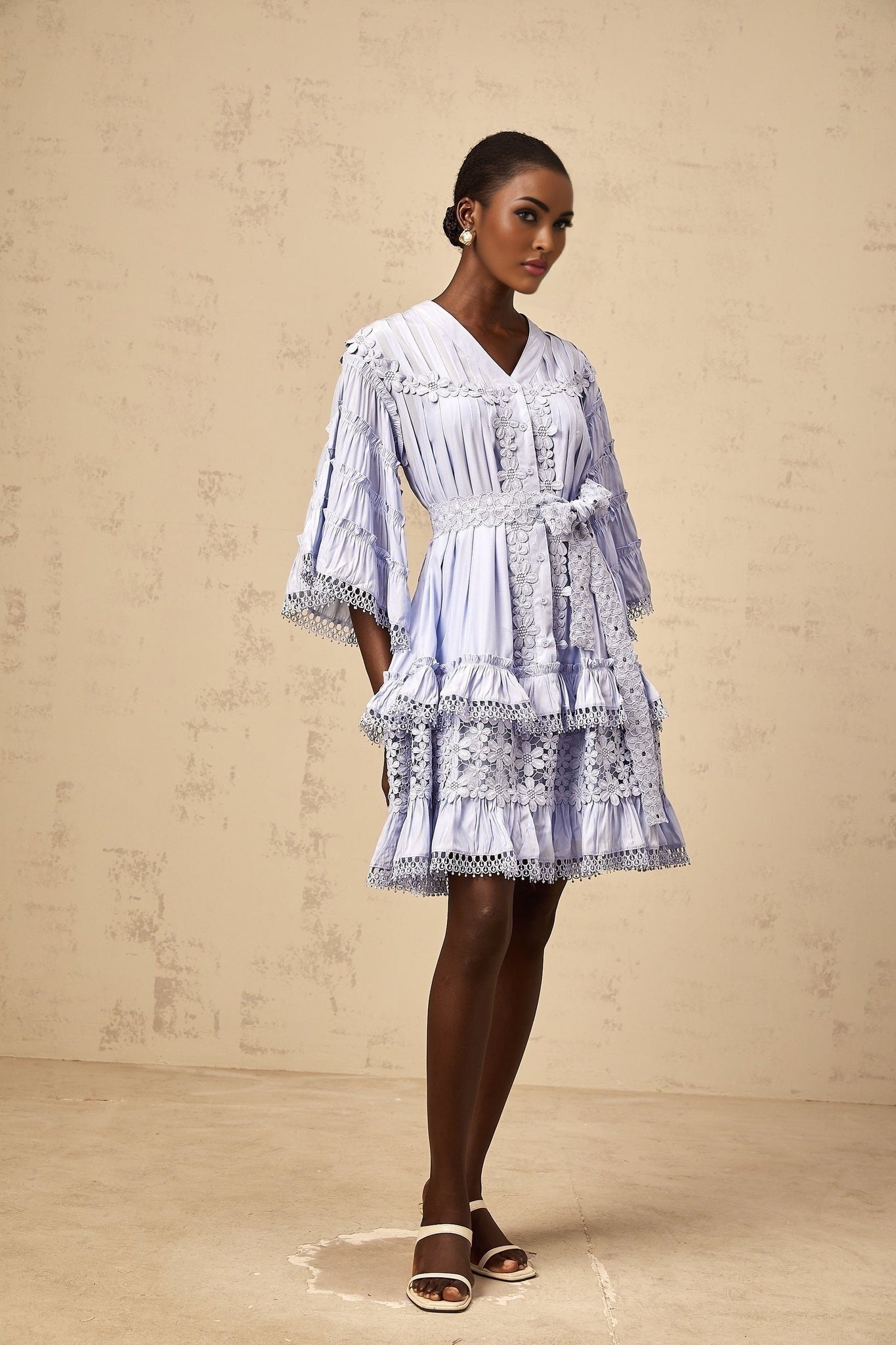 A light blue mini dress with tiered layers and delicate floral embroidery details