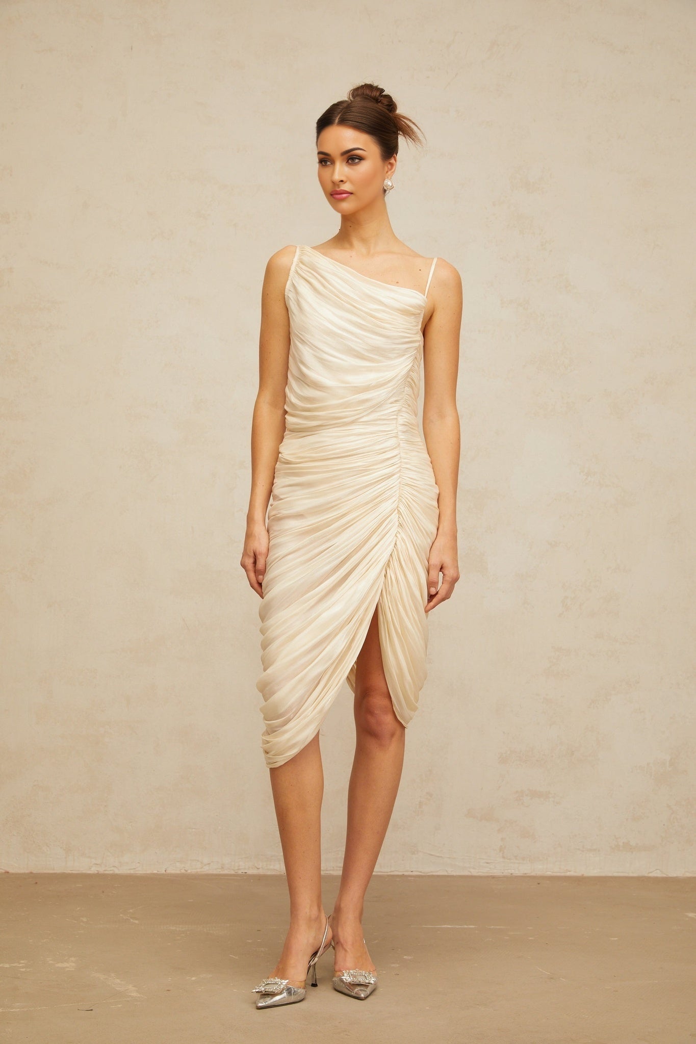 A light yellow glossy midi dress with ruched detailing and a sleek silhouette