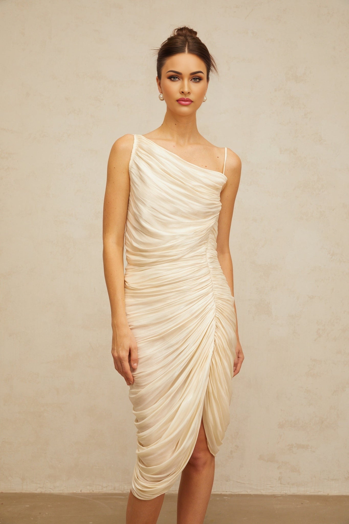 A light yellow glossy midi dress with ruched detailing and a sleek silhouette