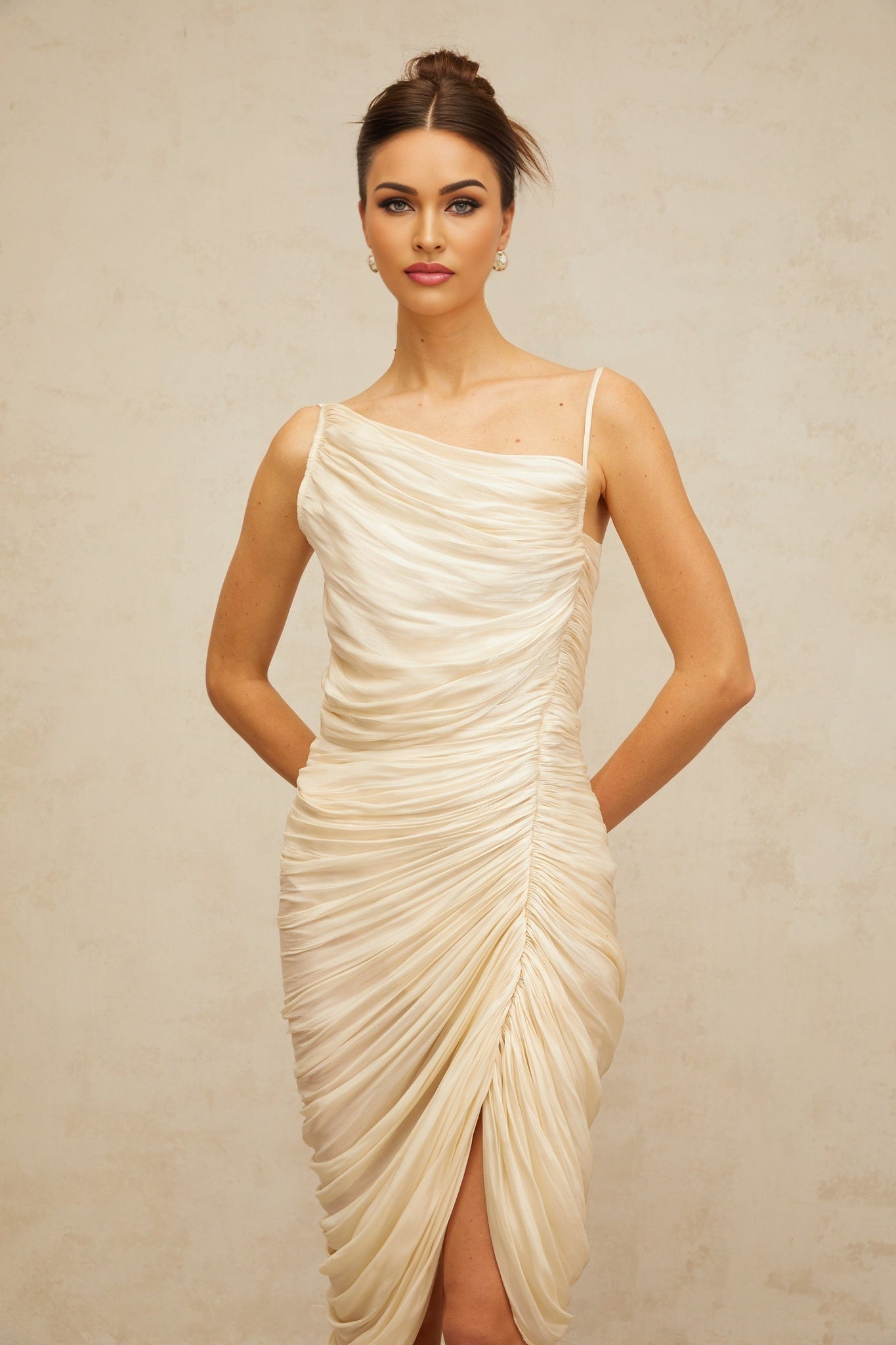 A light yellow glossy midi dress with ruched detailing and a sleek silhouette