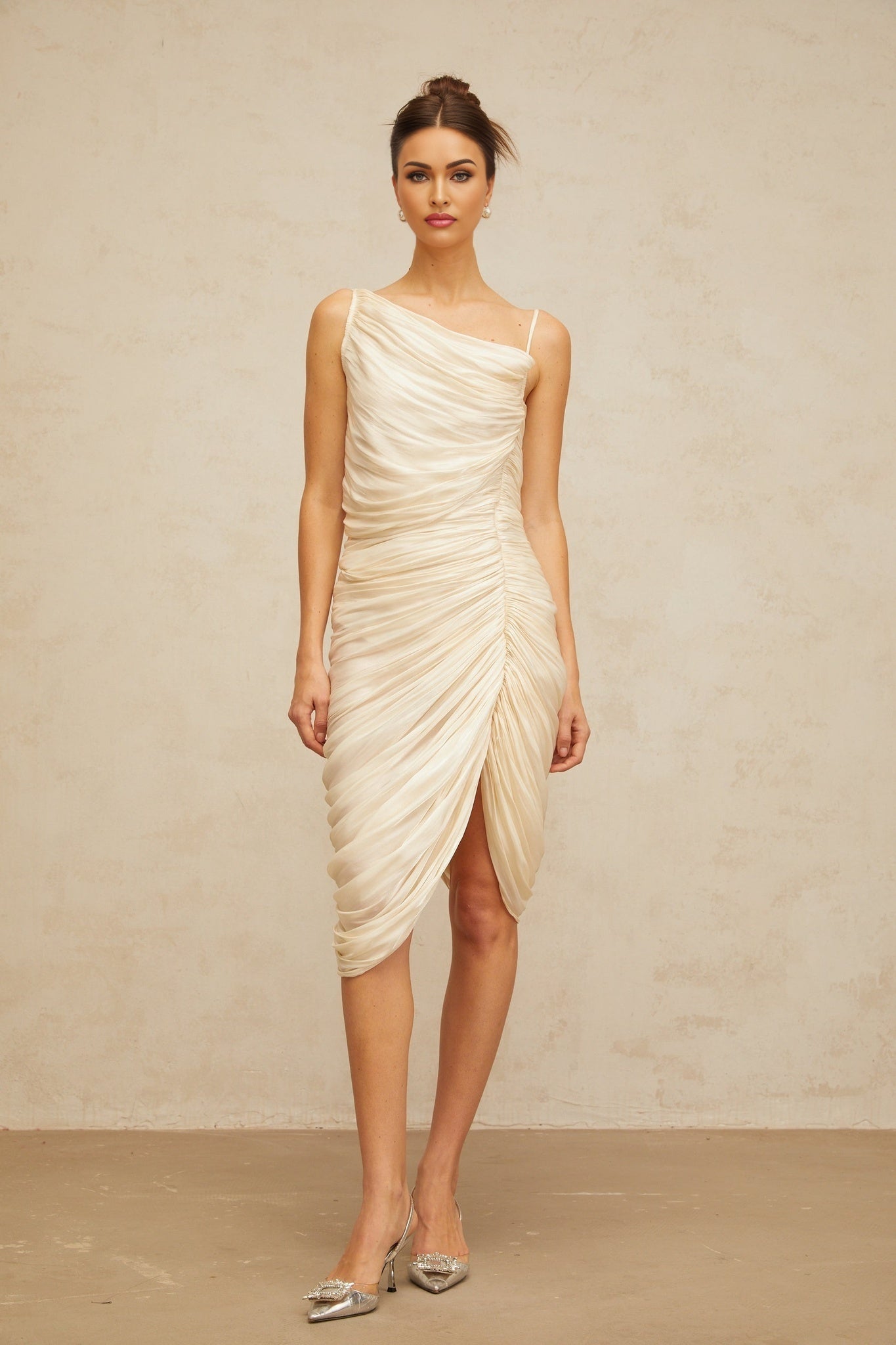 A light yellow glossy midi dress with ruched detailing featuring a sleek silhouette and shiny fabric