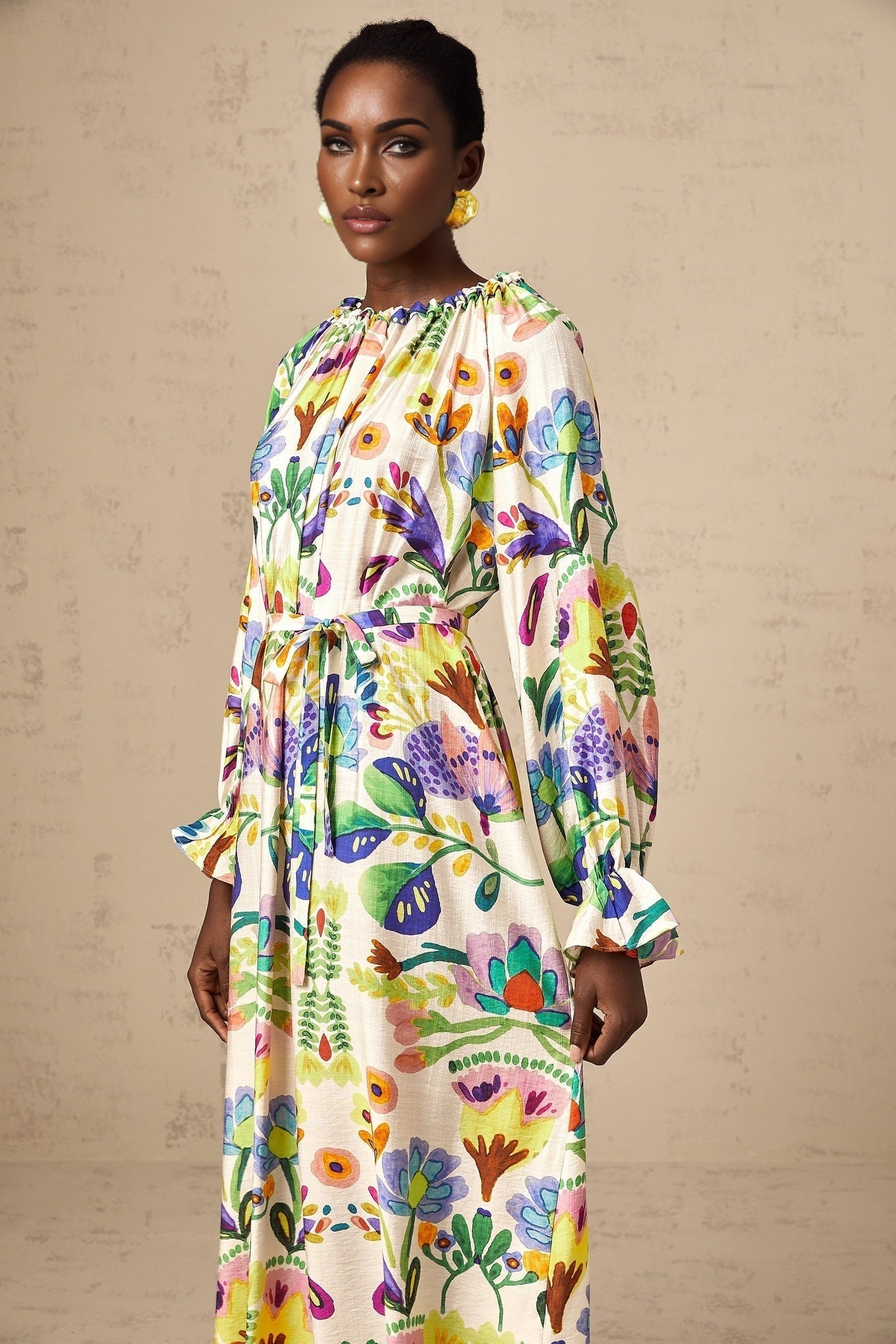 A lightcolored midi dress with a paisley print pattern on poplin fabric featuring a flowy silhouette and feminine details