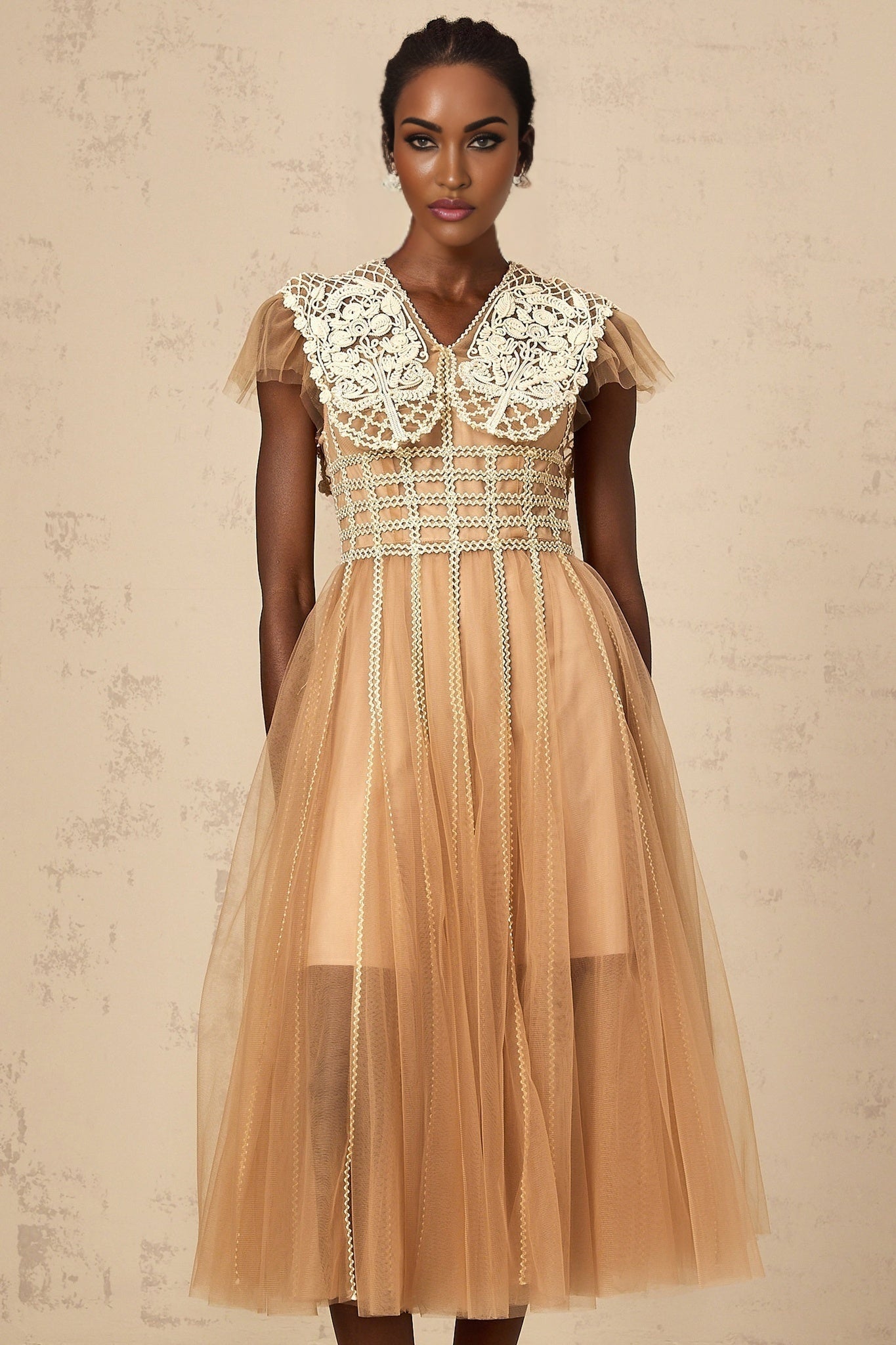 A lightcolored midi dress with lace panels and tulle details featuring a delicate and feminine design