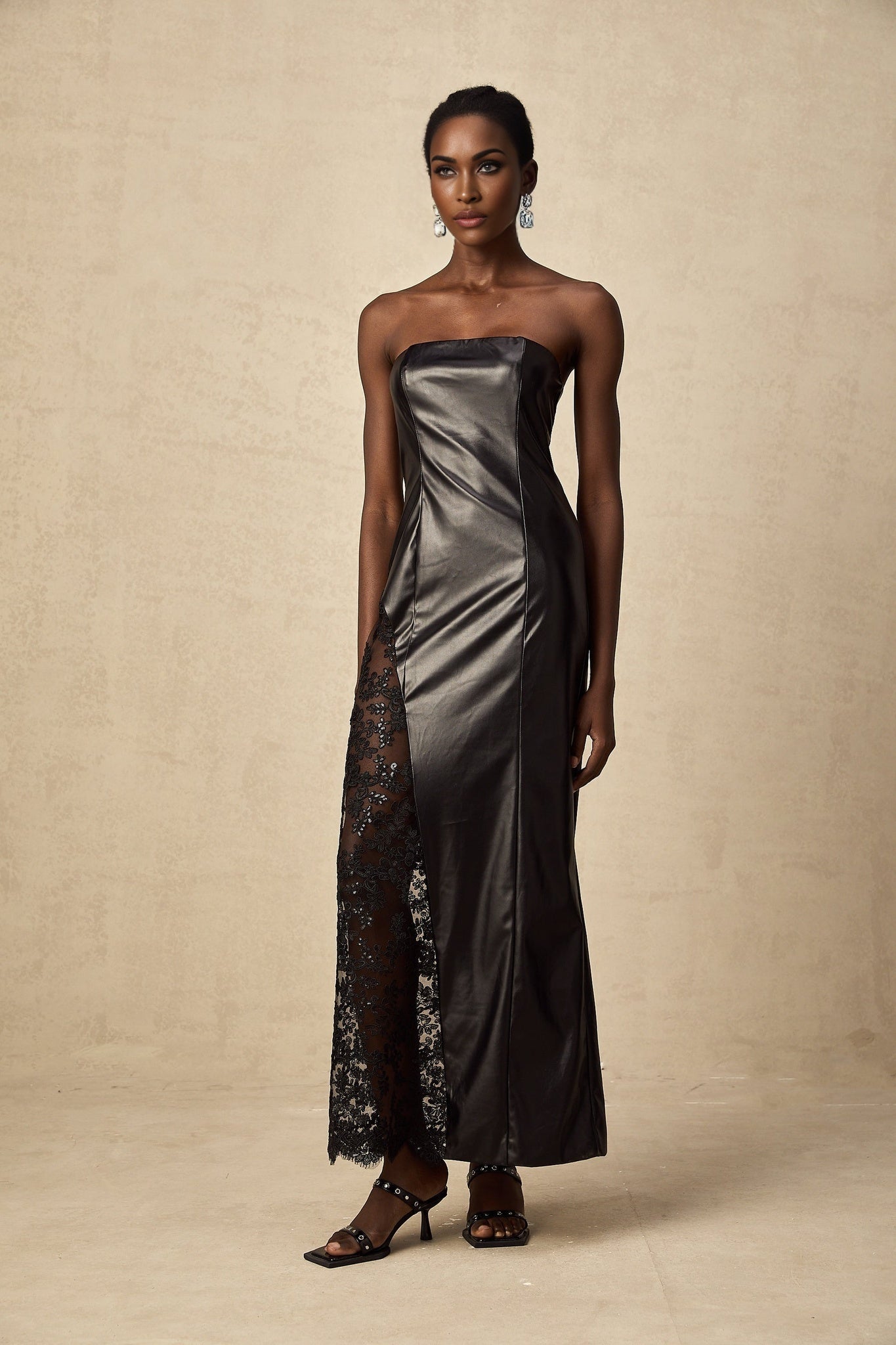 A long black dress with a faux leather bodice and lace panels reaching to the floor
