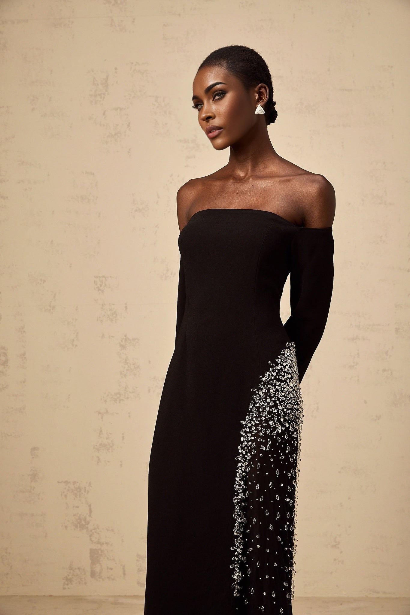 A long black maxi dress with sheer mesh panels and embellished details featuring a flowy silhouette and elegant design