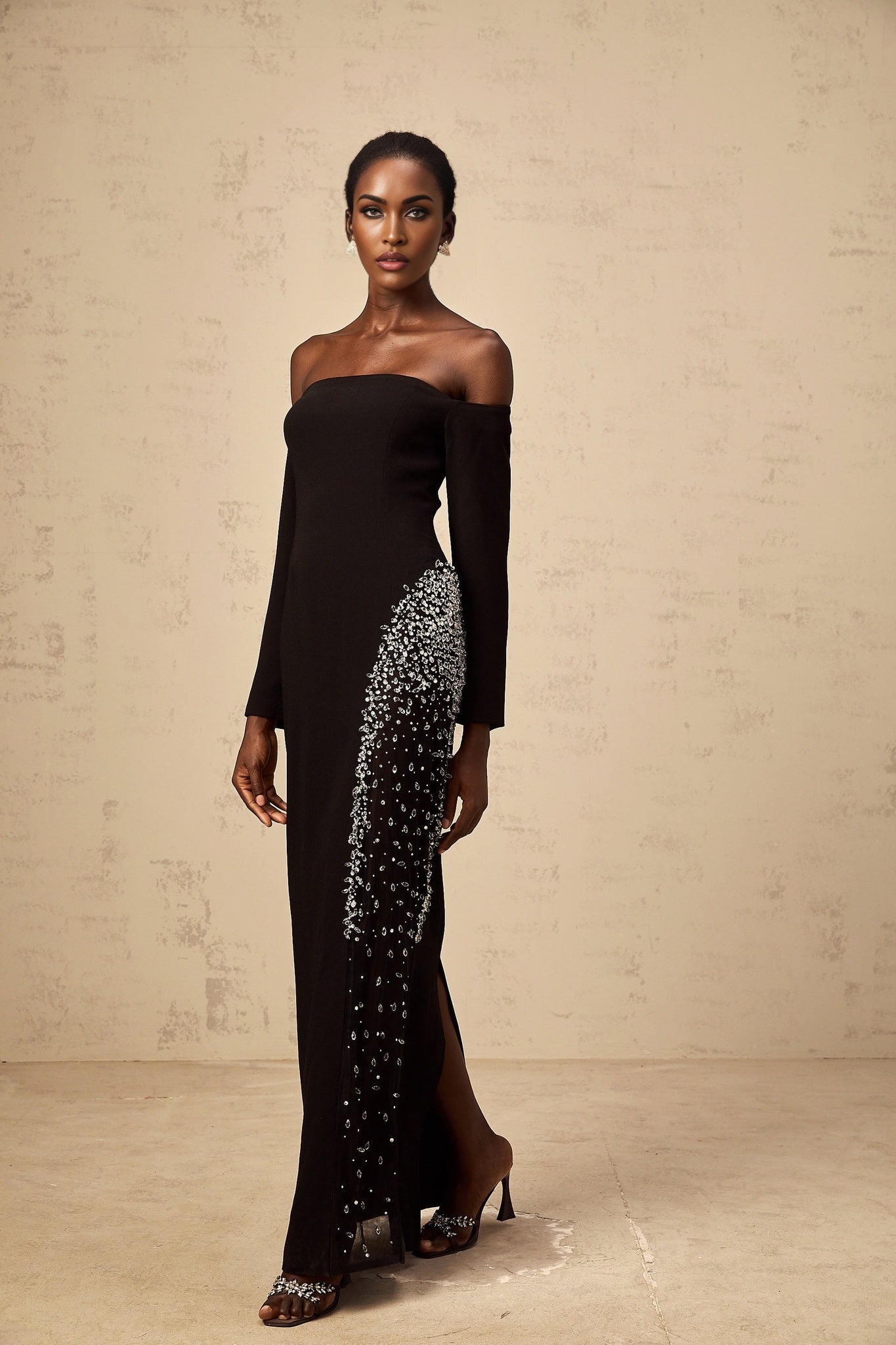 A long black maxi dress with sheer mesh panels and embellished details featuring a sleek silhouette and elegant design