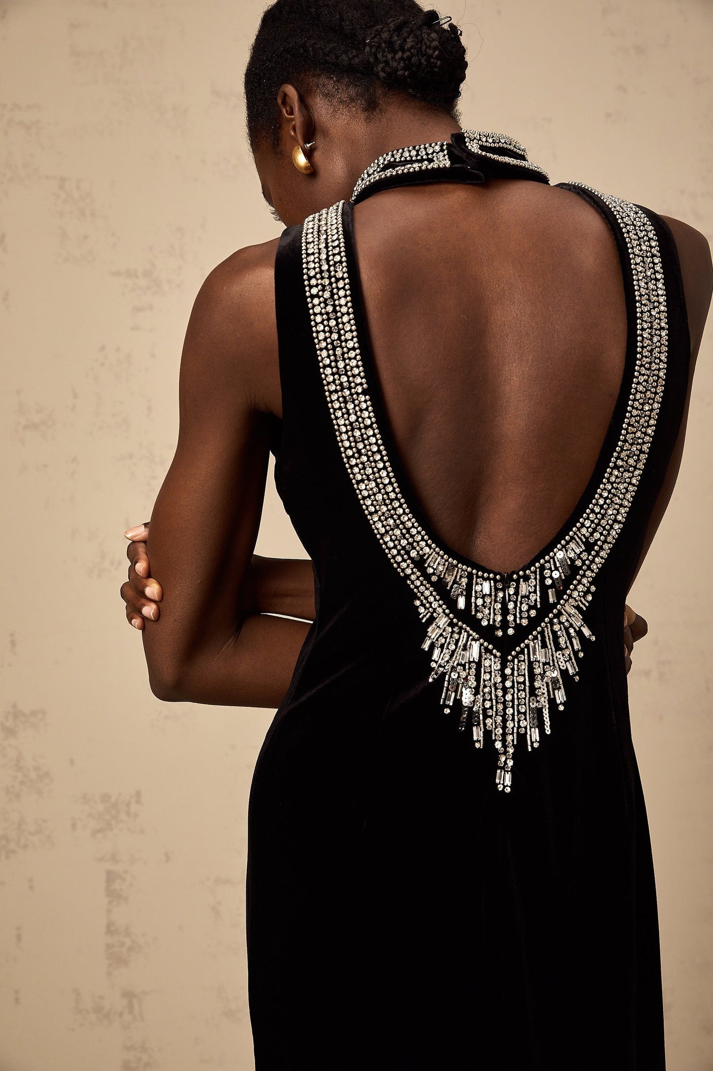 A long black velvet gown adorned with crystal embellishments featuring a sleek silhouette and elegant design