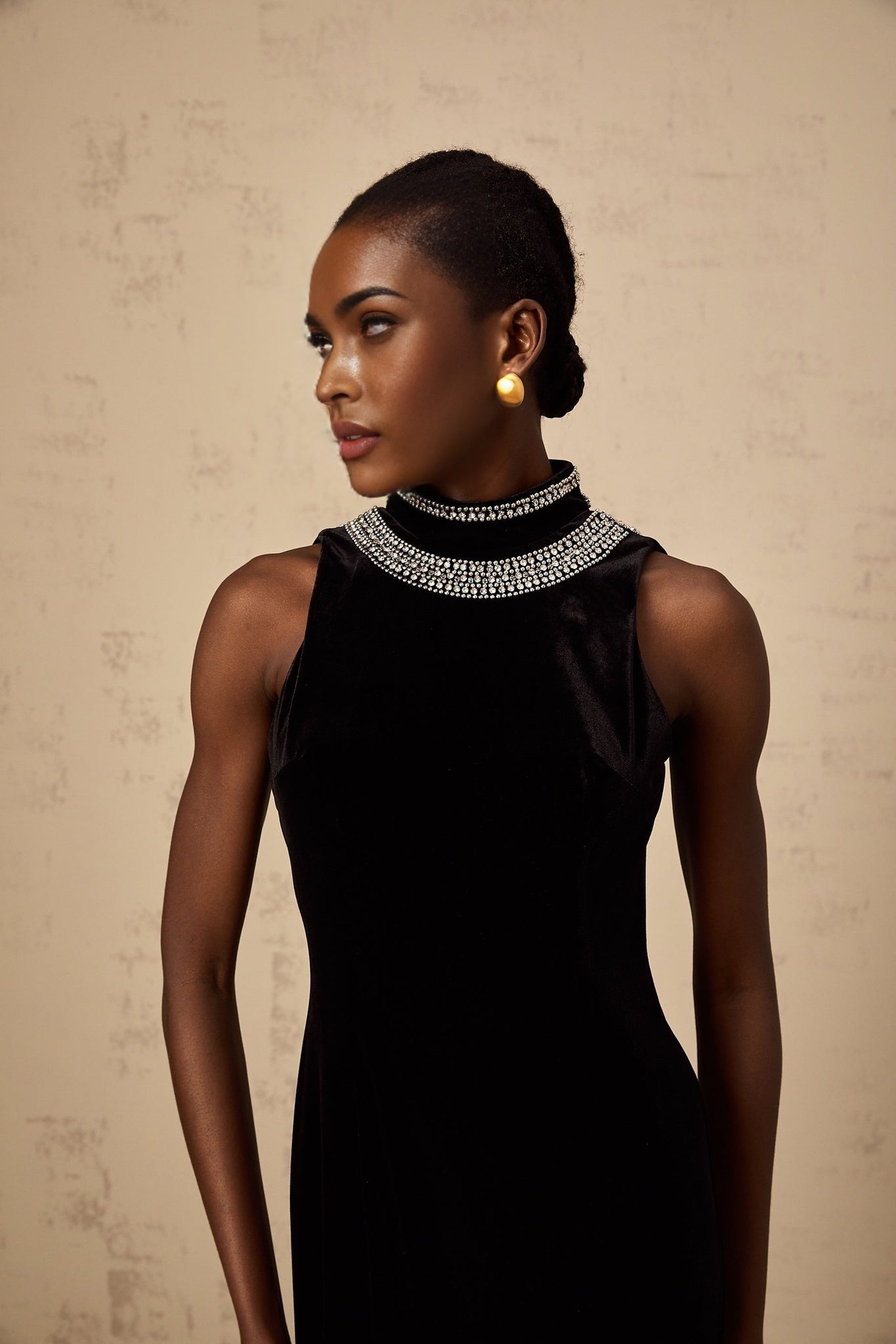 A long black velvet gown with crystal embellishments named Colette on a mannequin or model