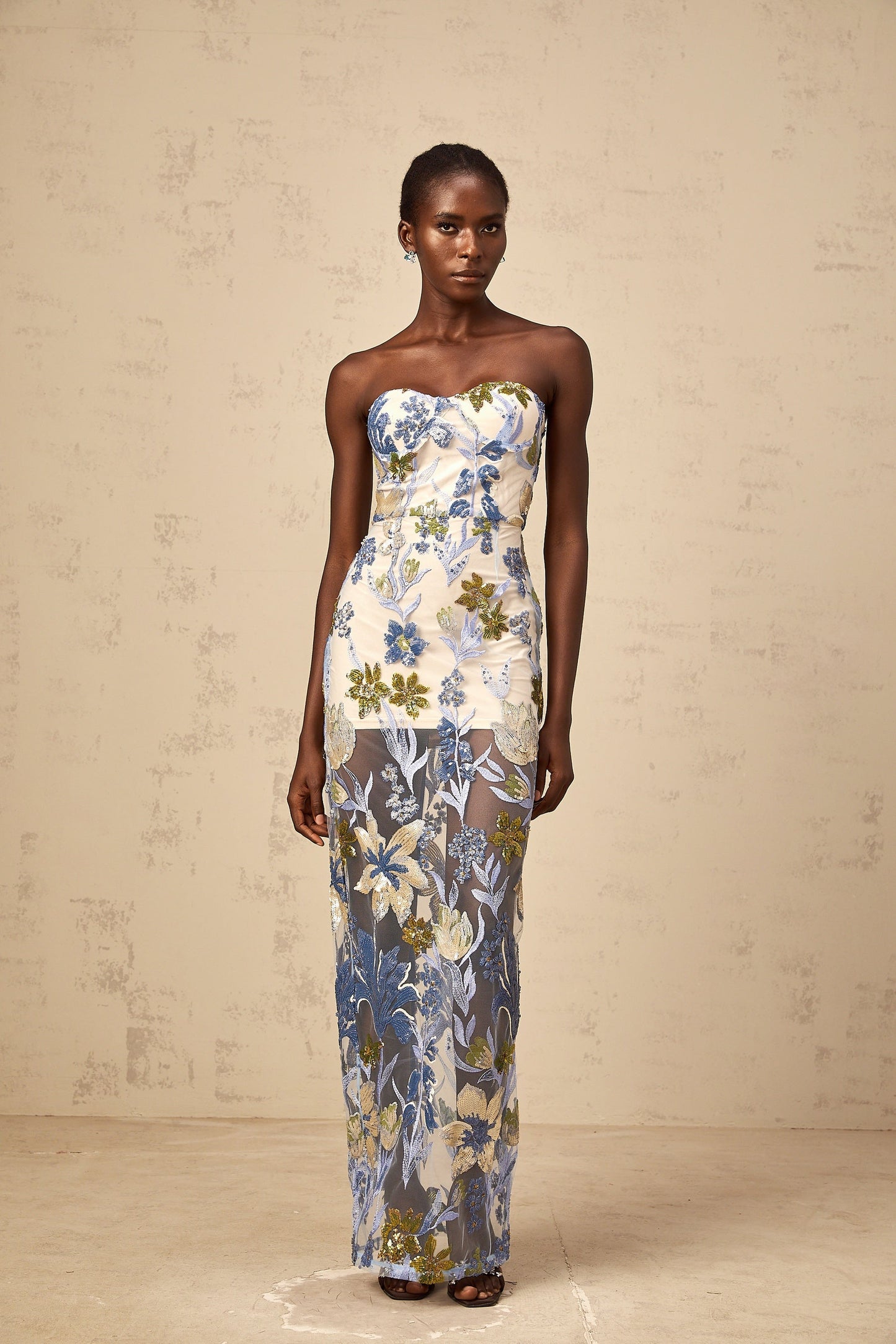 A long blue maxi dress with a corset bodice featuring sequined flower embroidery and a flowing tulle skirt