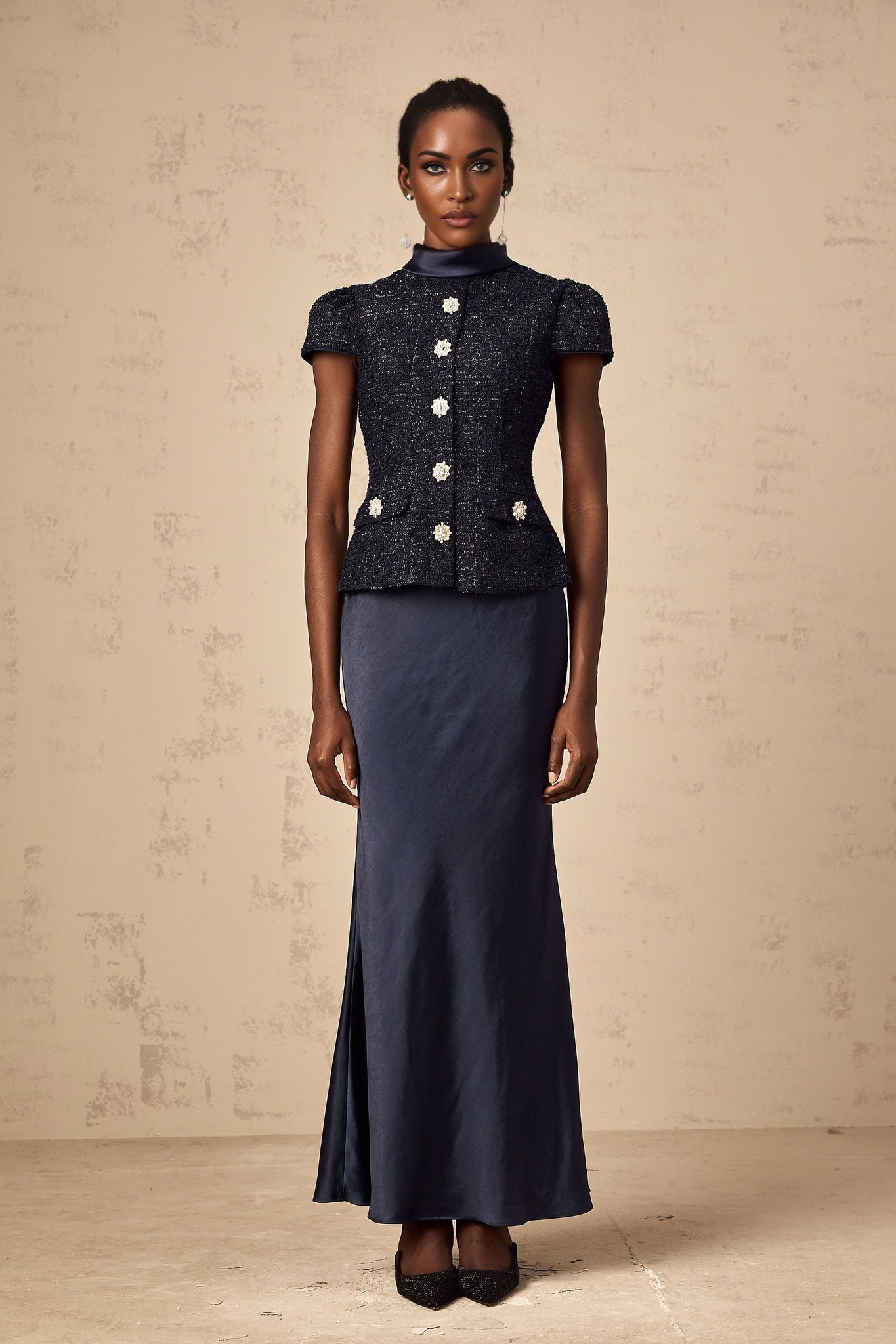 A long blue maxi dress with a peplum waist and paneled design featuring a fitted bodice and flowing skirt