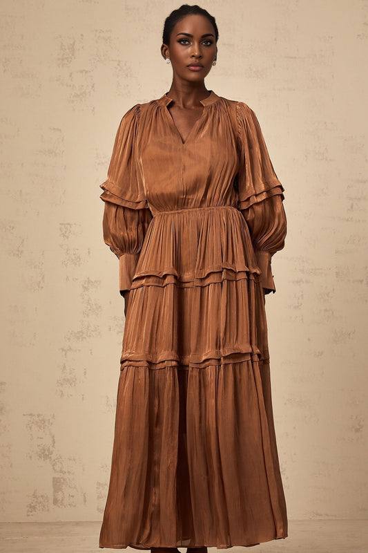 A long brown maxi dress with ruffled trim and tiered layers featuring a flowing silhouette and feminine design
