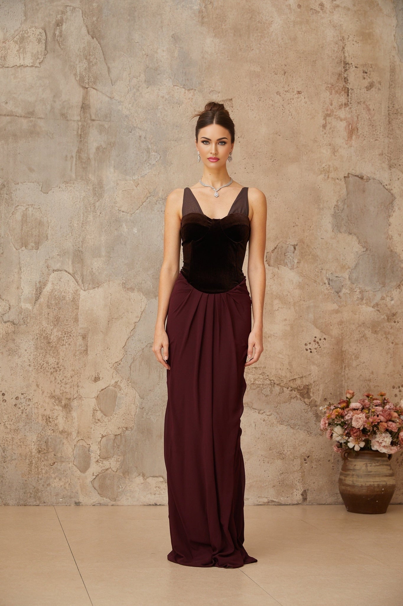 A long burgundy maxi dress with velvet panels and shirred detailing