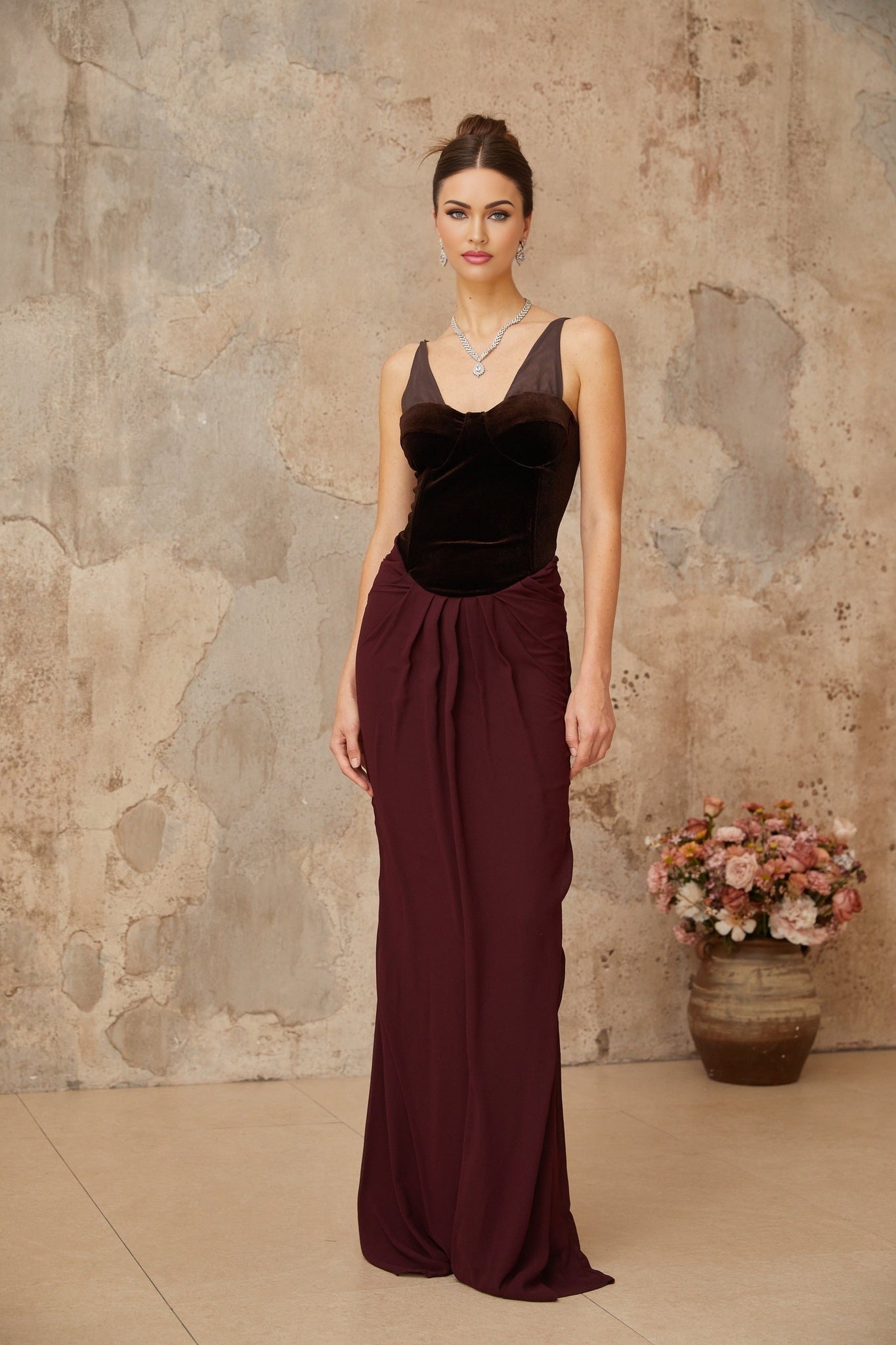 A long burgundy maxi dress with velvet panels and shirred detailing