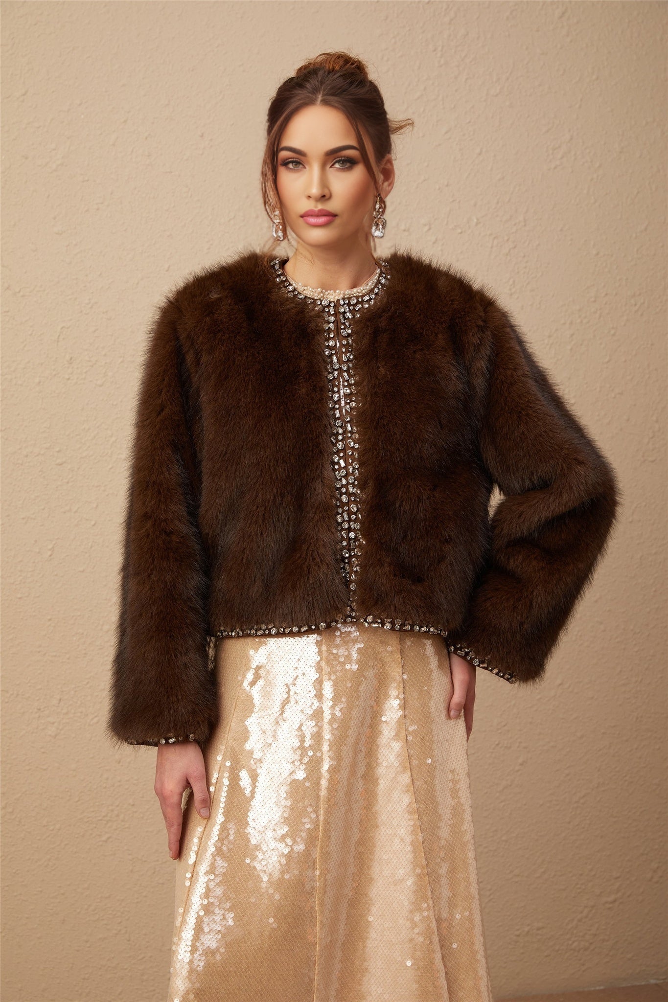 A long faux fur coat with ombre effect transitioning from light to dark shades featuring crystal embellishments and a luxurious appearance