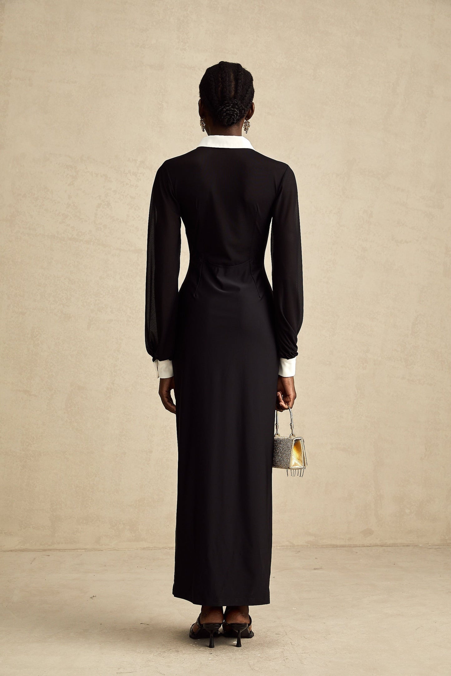 A long flowing maxi dress with contrasting colors and semisheer fabric featuring a delicate and feminine design
