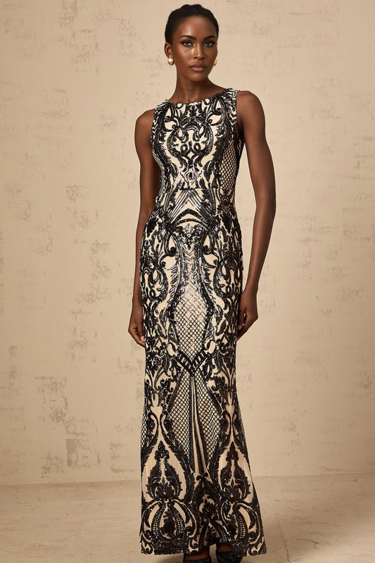 A long flowing maxi dress with sheer mesh fabric adorned with sparkling sequins creating a glamorous evening look