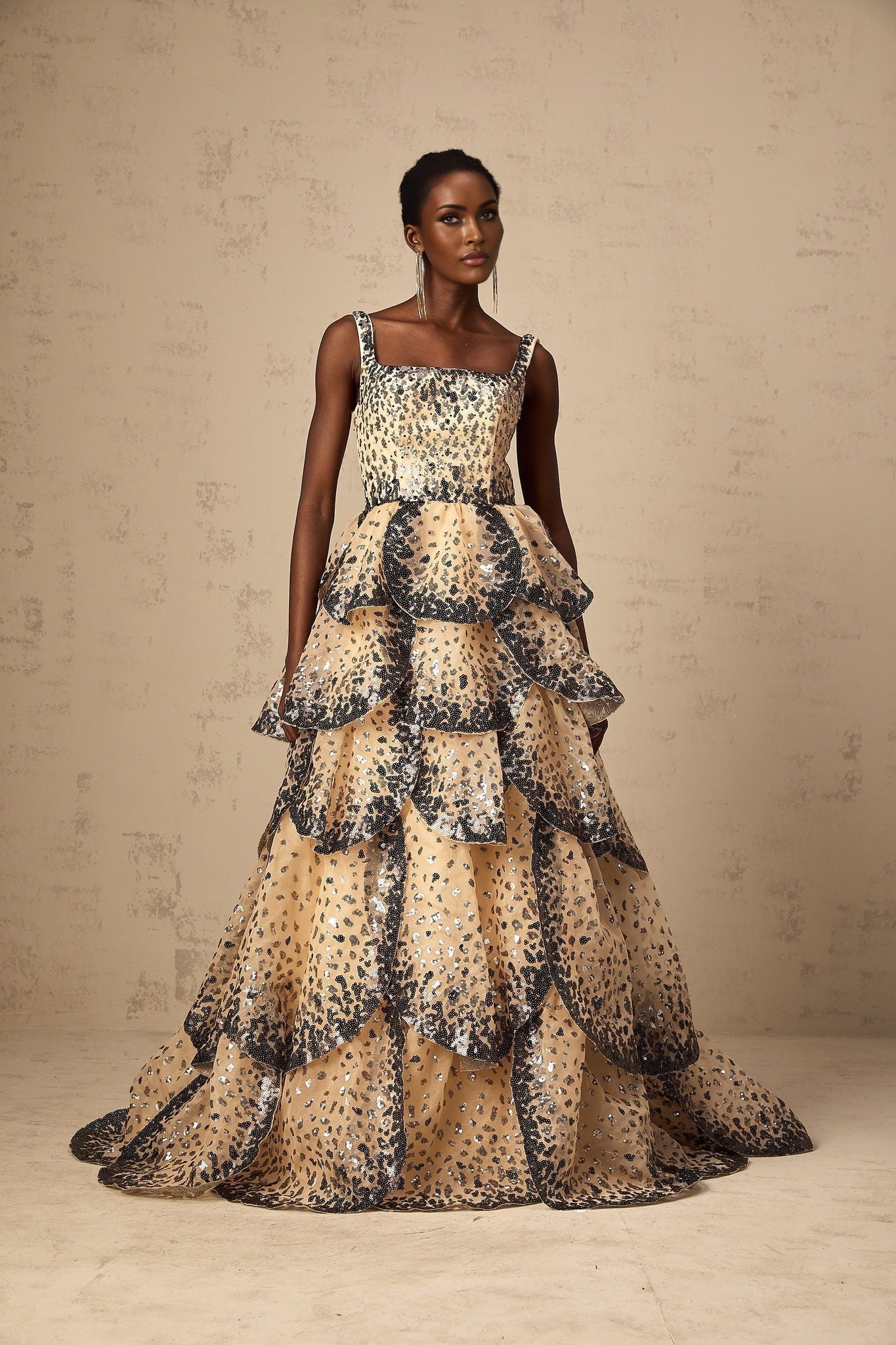 A long formal maxi dress with tiered layers of sequined petals cascading down the length creating a shimmering floral effect