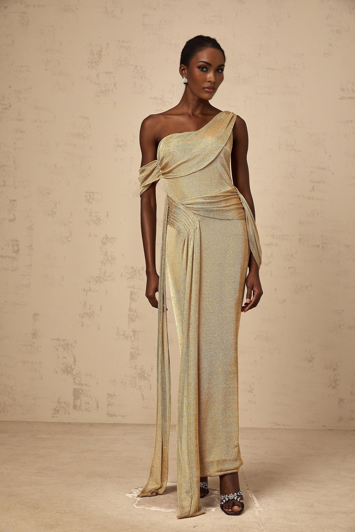 A long gold maxi dress with a gathered design and ribbon details