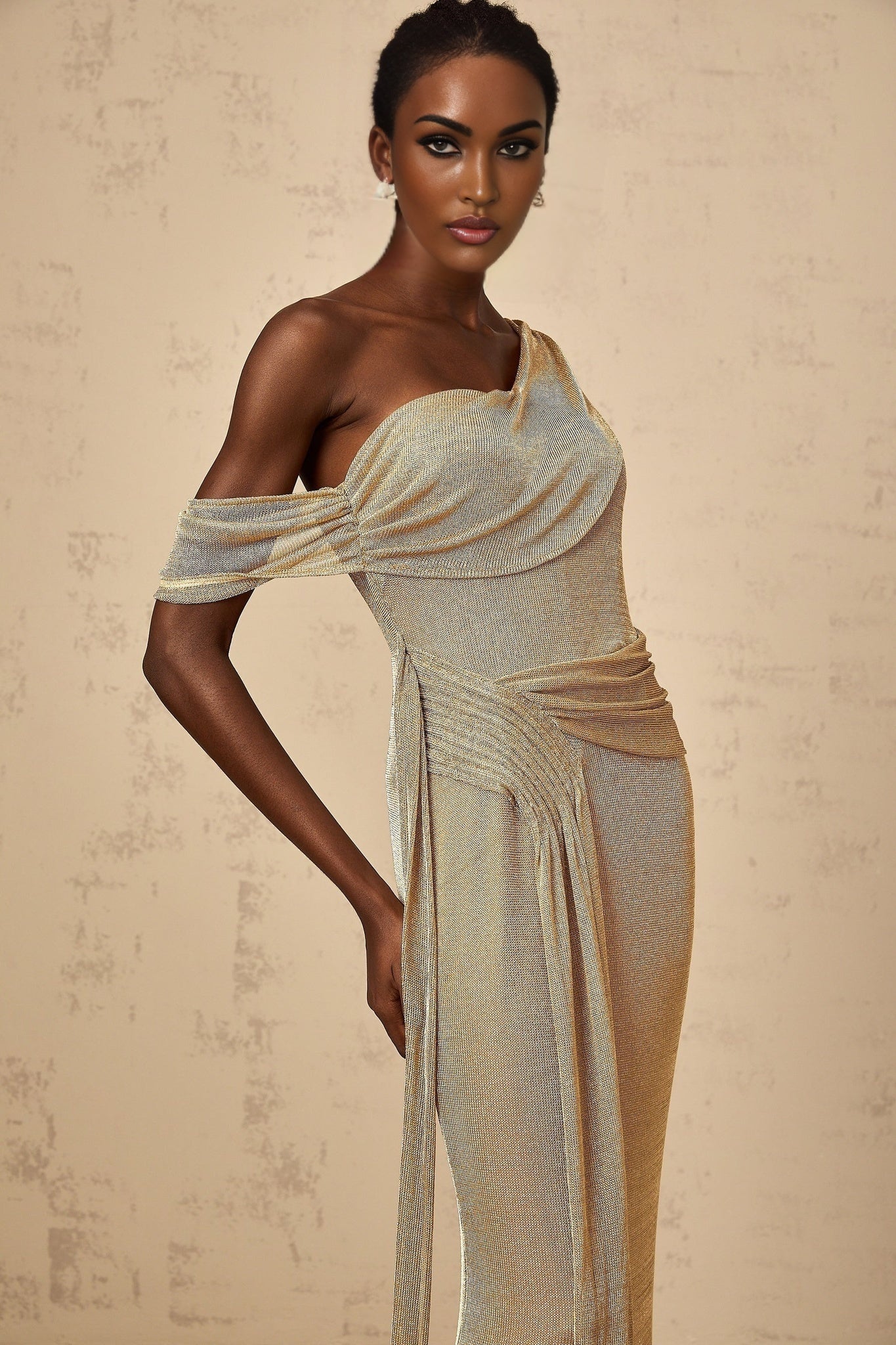 A long gold maxi dress with a gathered waist and ribbon design details