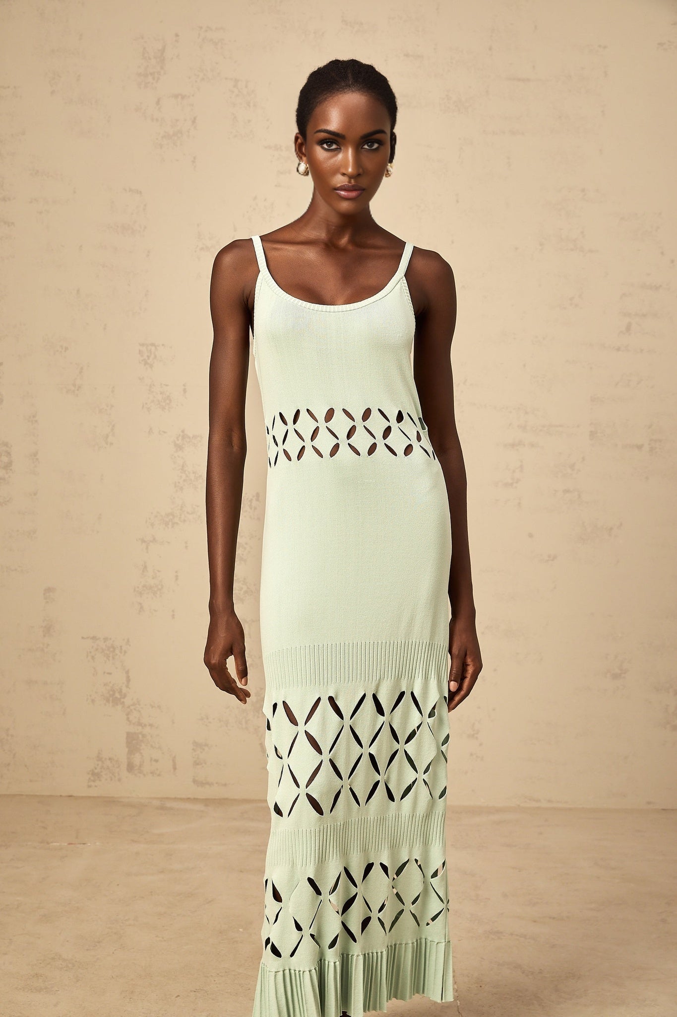 A long green knitted maxi dress with cutout details on a female model