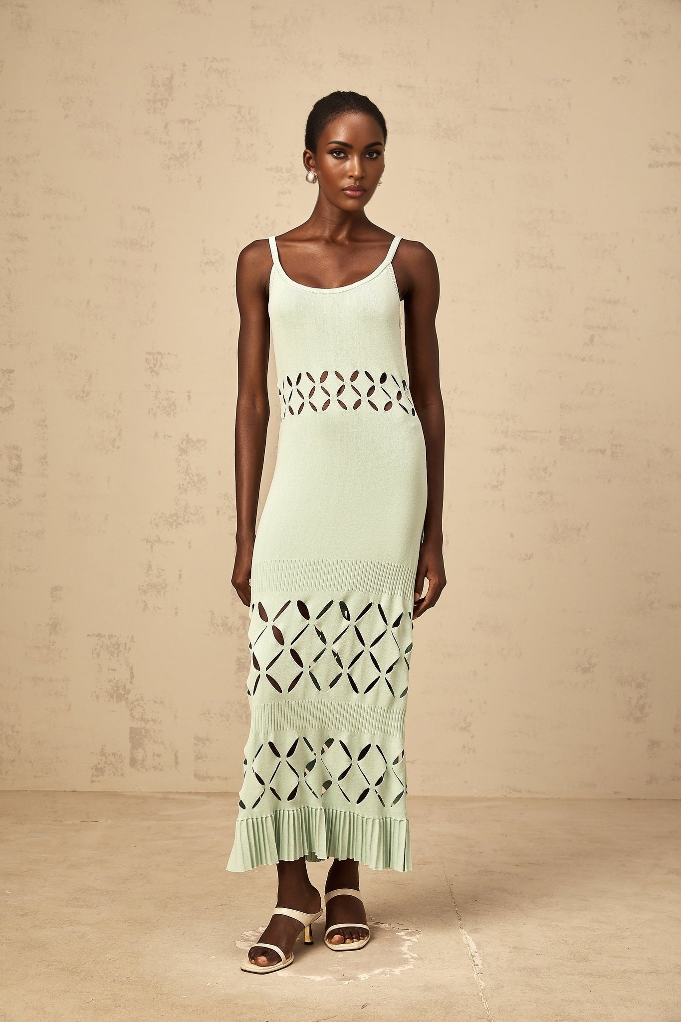 A long green knitted maxi dress with cutout details worn by a female model
