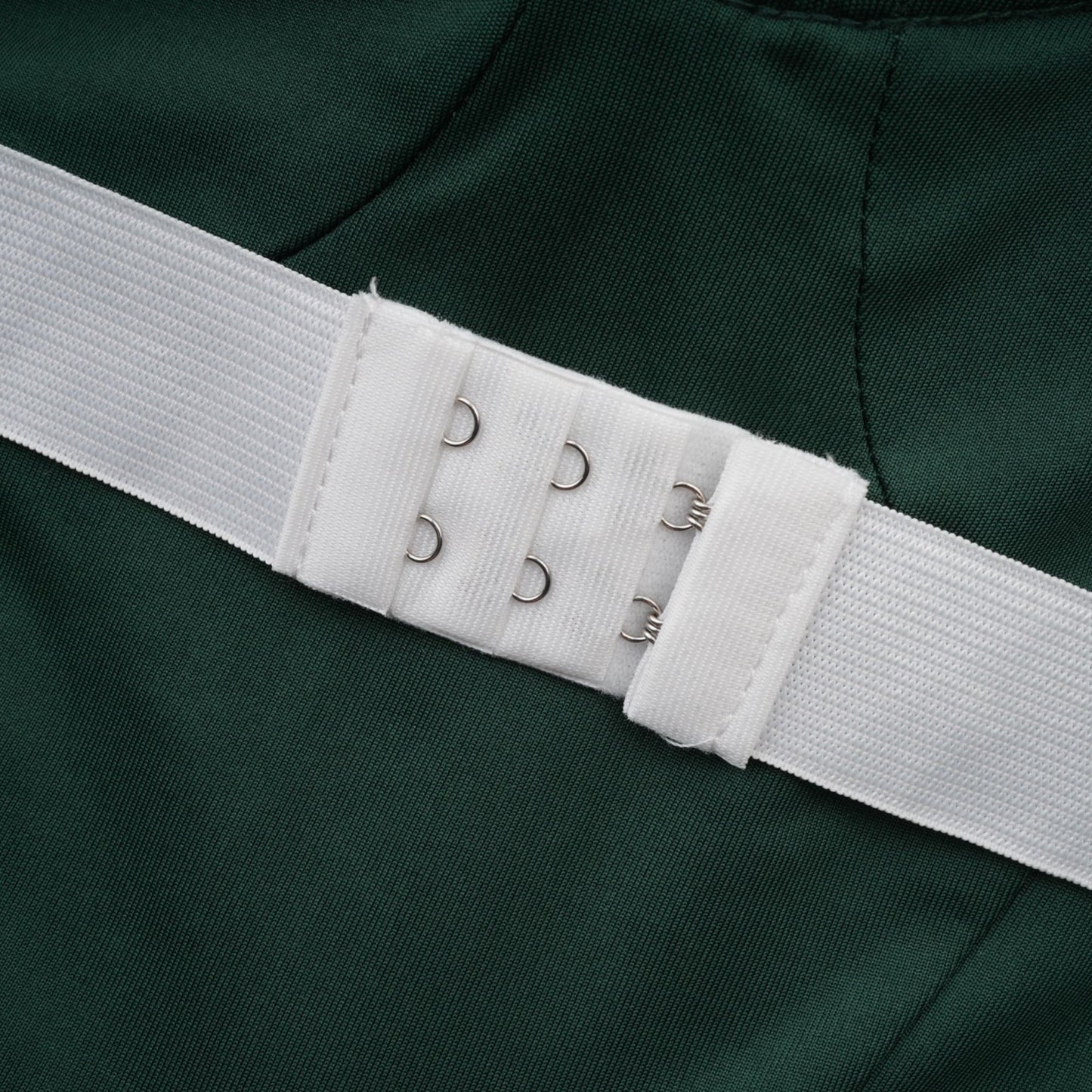 A long green maxi dress with a corset bodice featuring ribbon design details and a flowing skirt