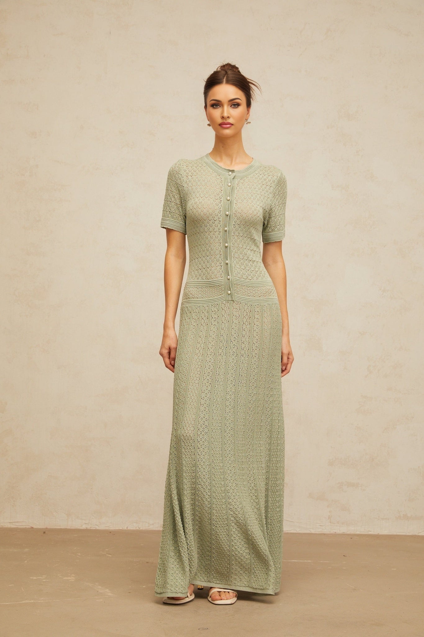 A long green maxi dress with shirred detailing and a crochet knit texture