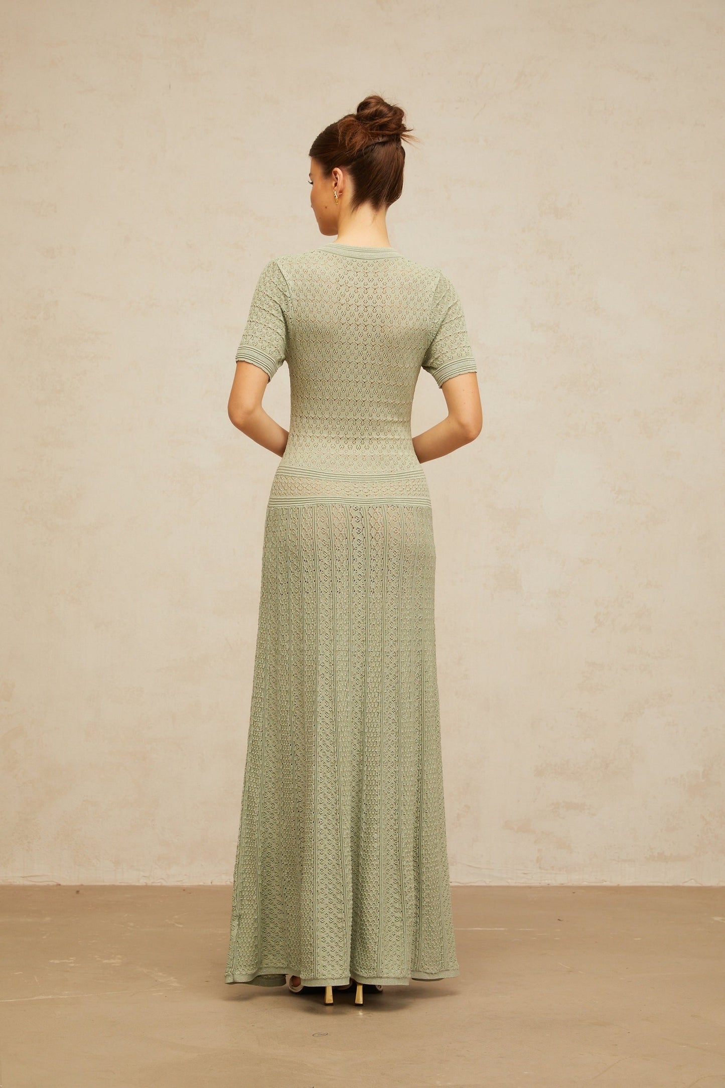 A long green maxi dress with shirred detailing and a crochet knit texture