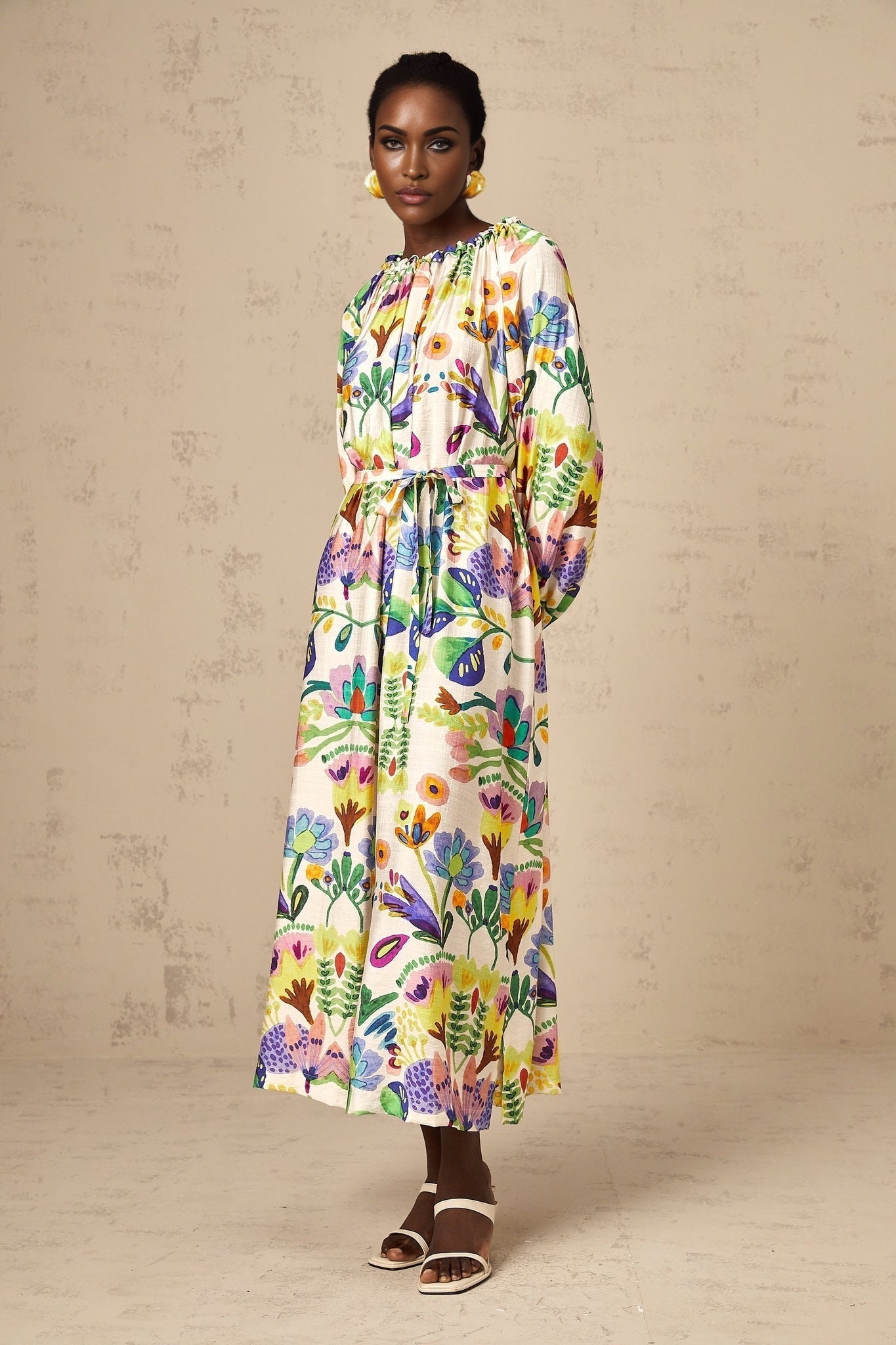 A long midi dress with a paisley print pattern on light poplin fabric featuring a flowy silhouette and vibrant colors
