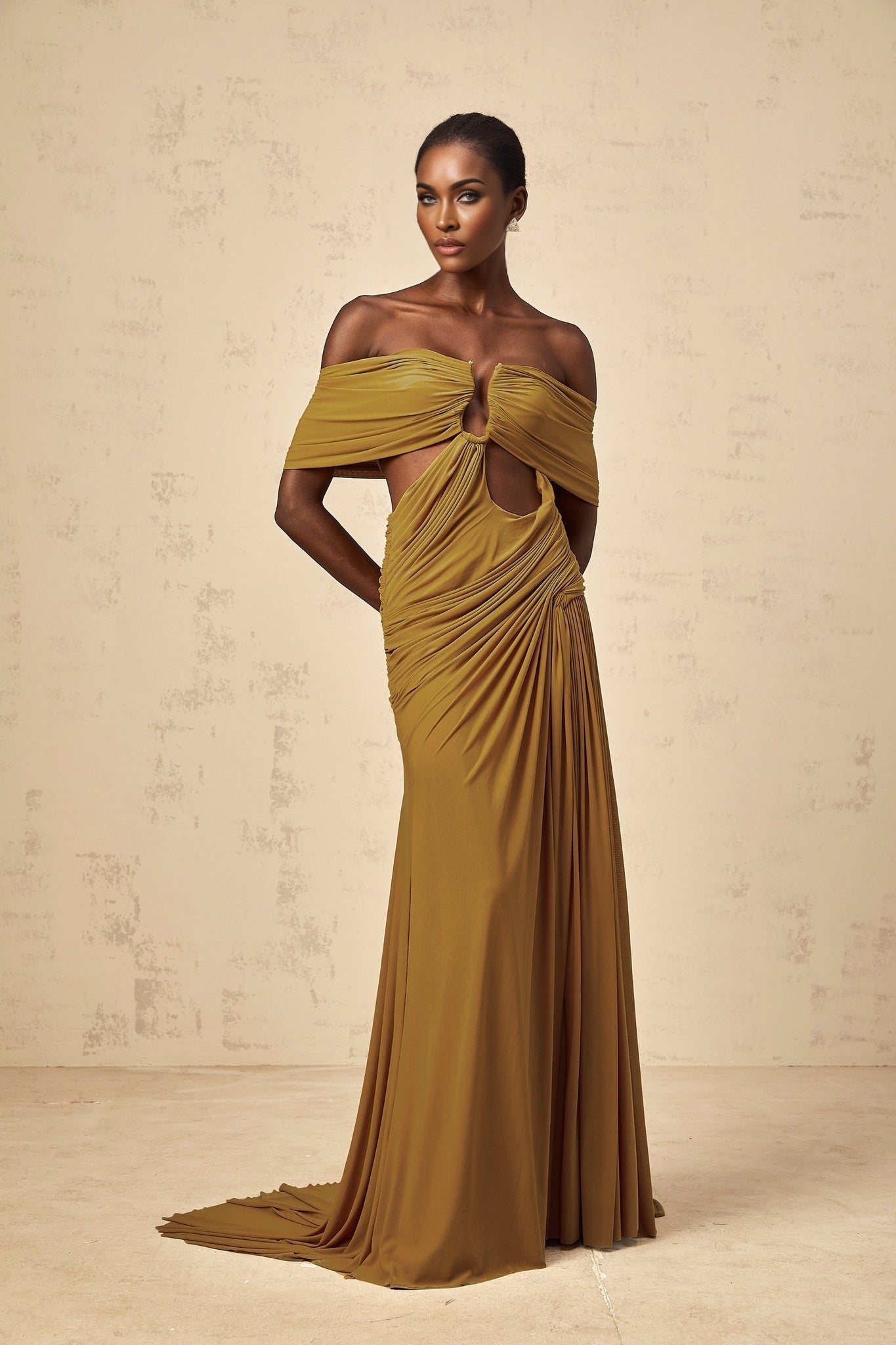 A long ocher maxi dress with offshoulder design and ruched details featuring a cutout element worn by a model against a plain background