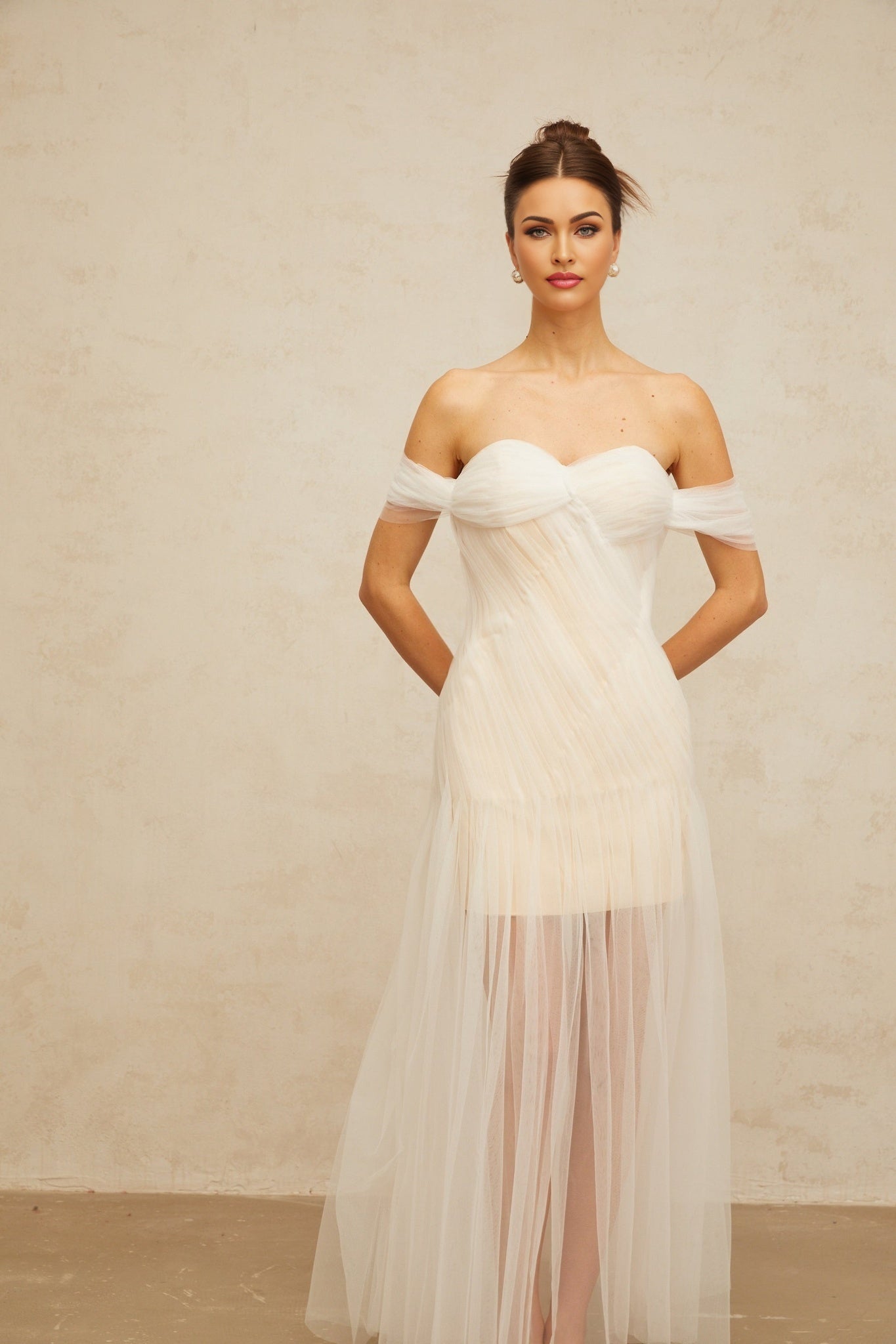 A long off white maxi dress with a pleated tulle skirt and fitted bodice