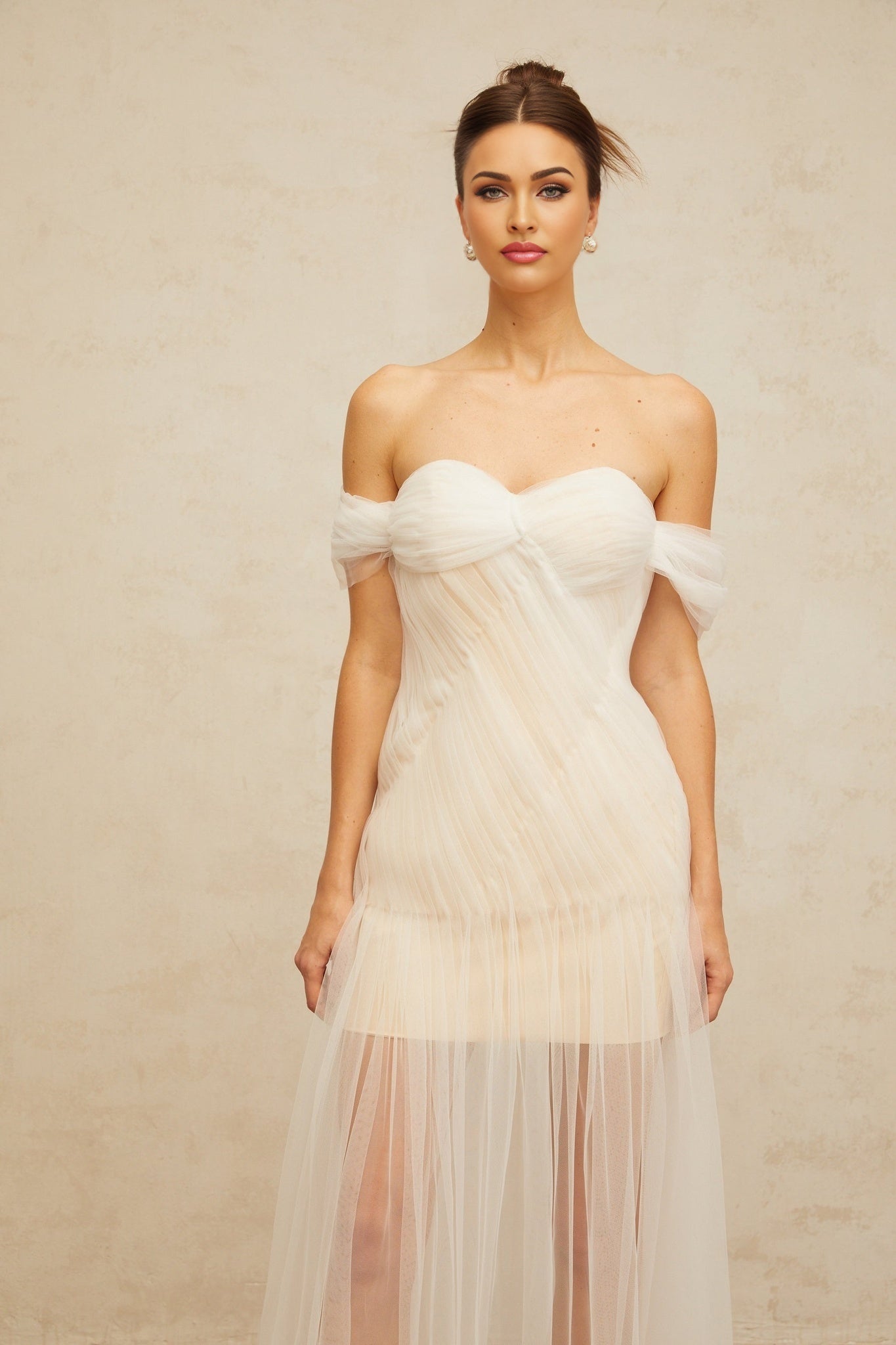 A long off white maxi dress with a pleated tulle skirt and fitted bodice