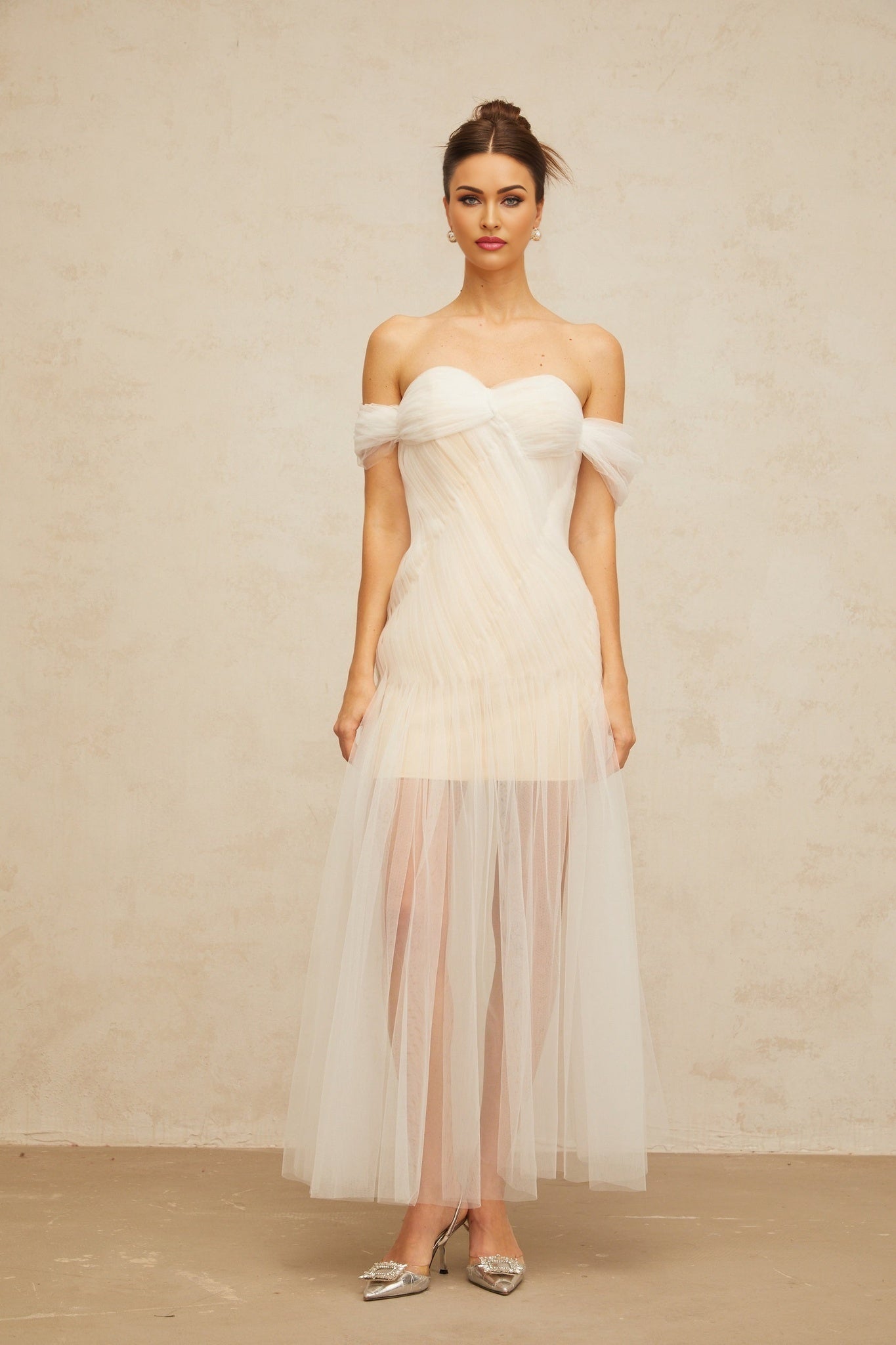 A long off white maxi dress with pleated tulle fabric and a flowing silhouette