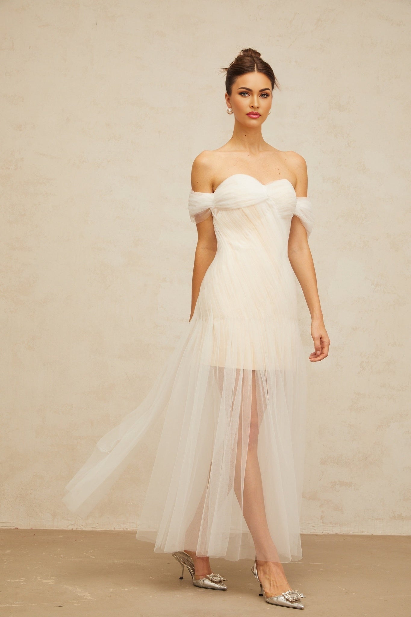 A long off white maxi dress with pleated tulle fabric and flowing skirt