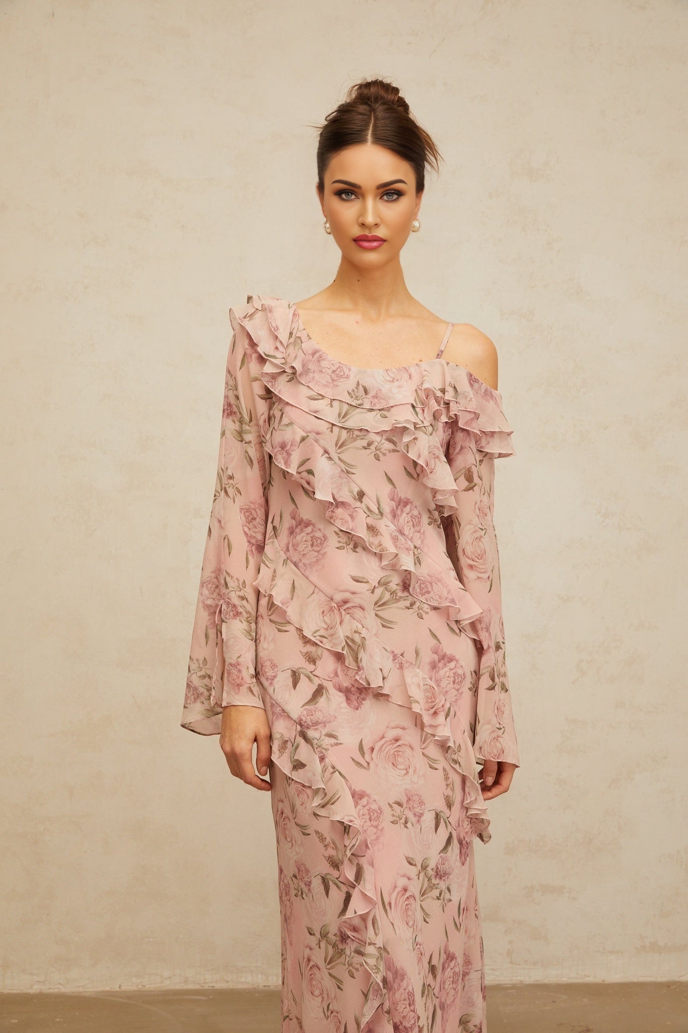 A long pink maxi dress with a floral print pattern and ruffled details named Clemence