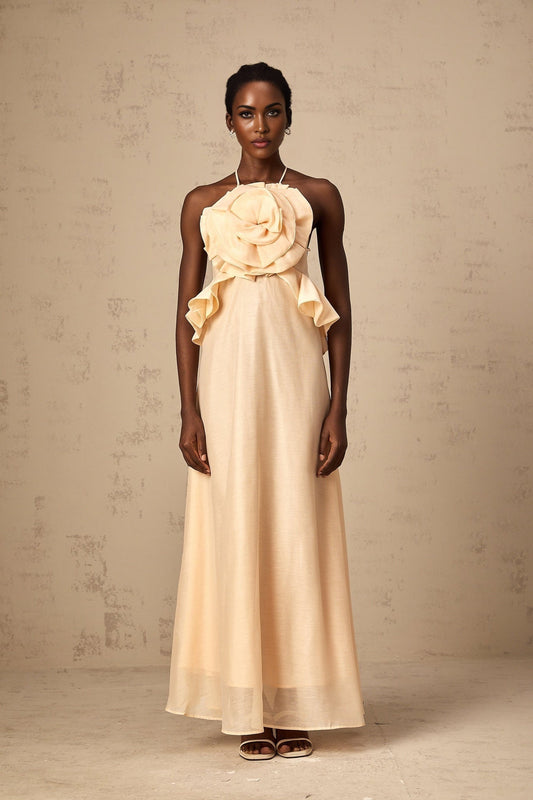 A long pink maxi dress with ruffled 3d petal details throughout creating a textured floral appearance