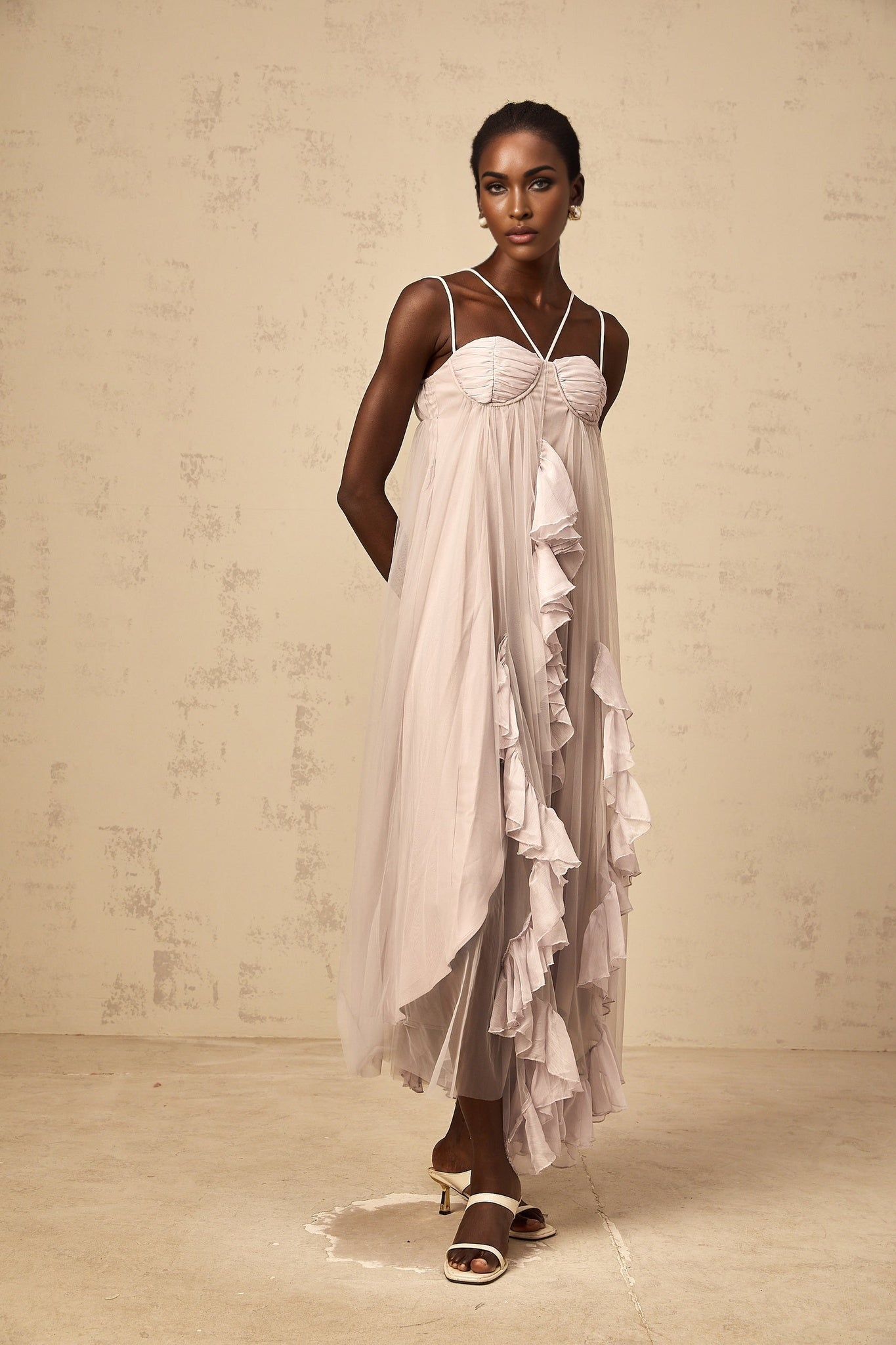 A long purple maxi dress with multiple layers of ruffled tulle fabric creating a flowing and ethereal appearance
